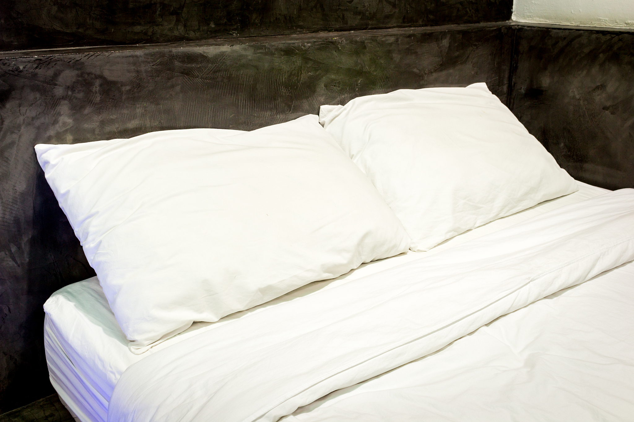 white pillows on a bed and bedding sheets