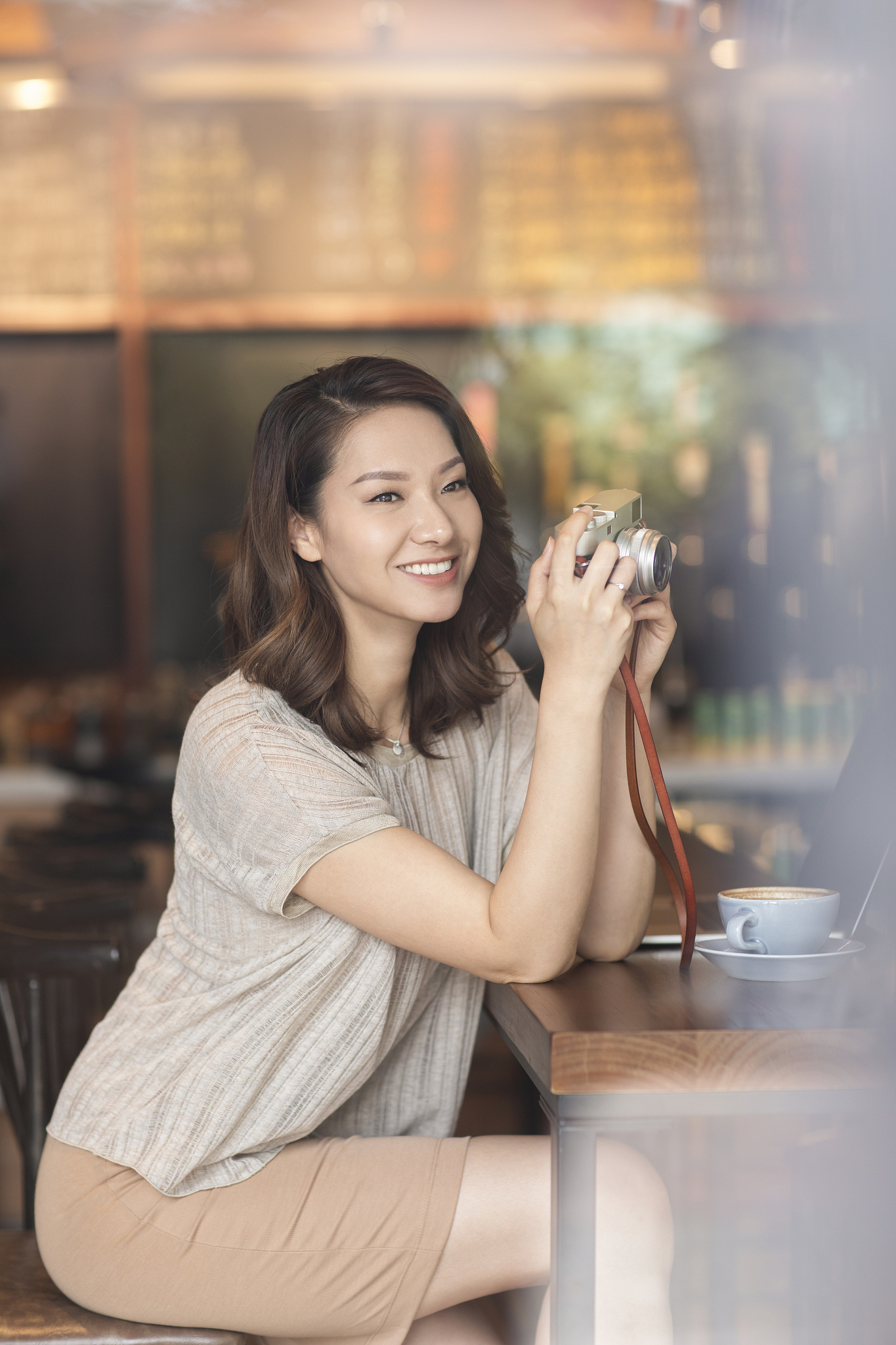 优雅女士在咖啡店使用相机
