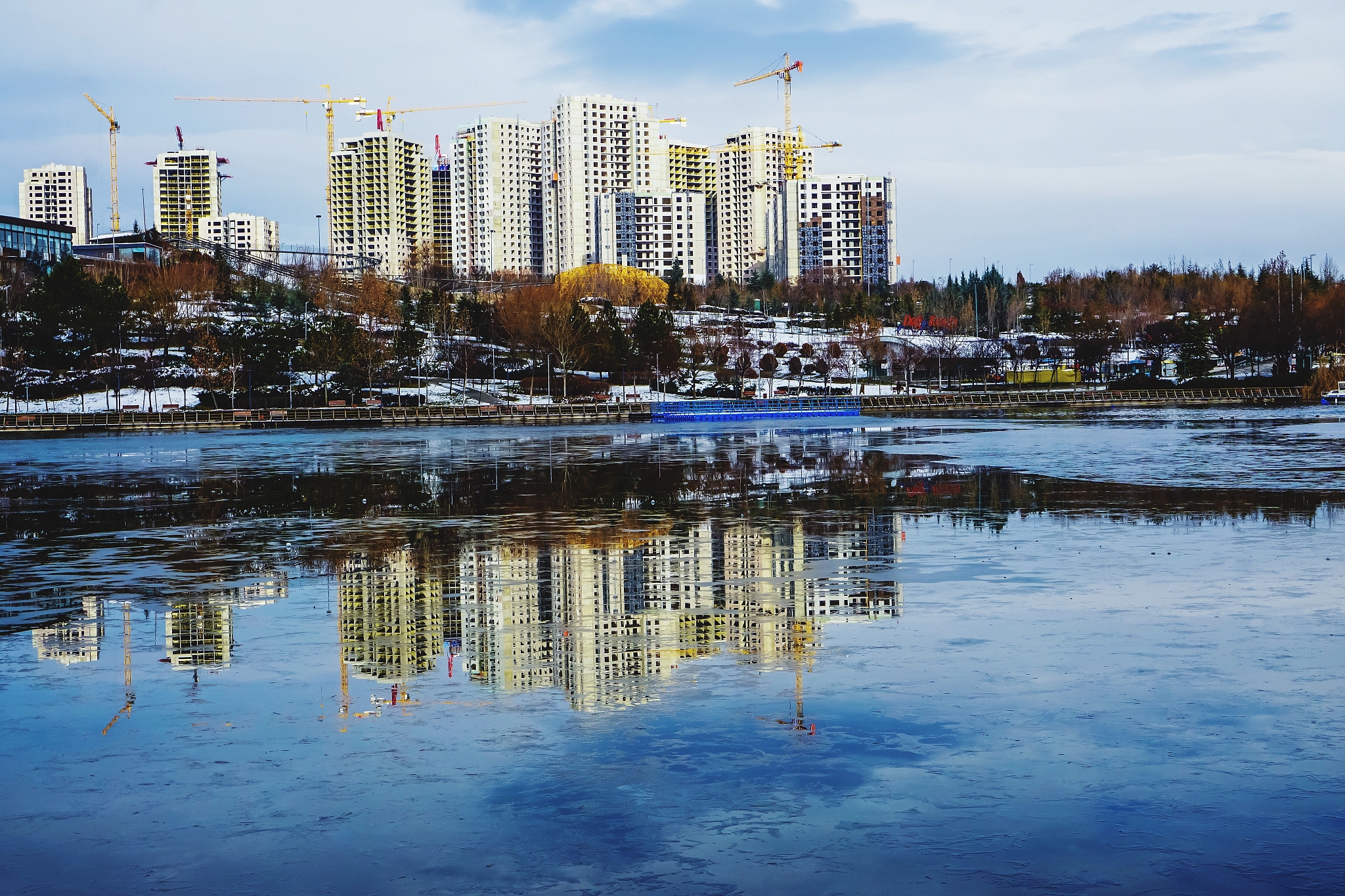 reflection of buildings in lake against sky in city