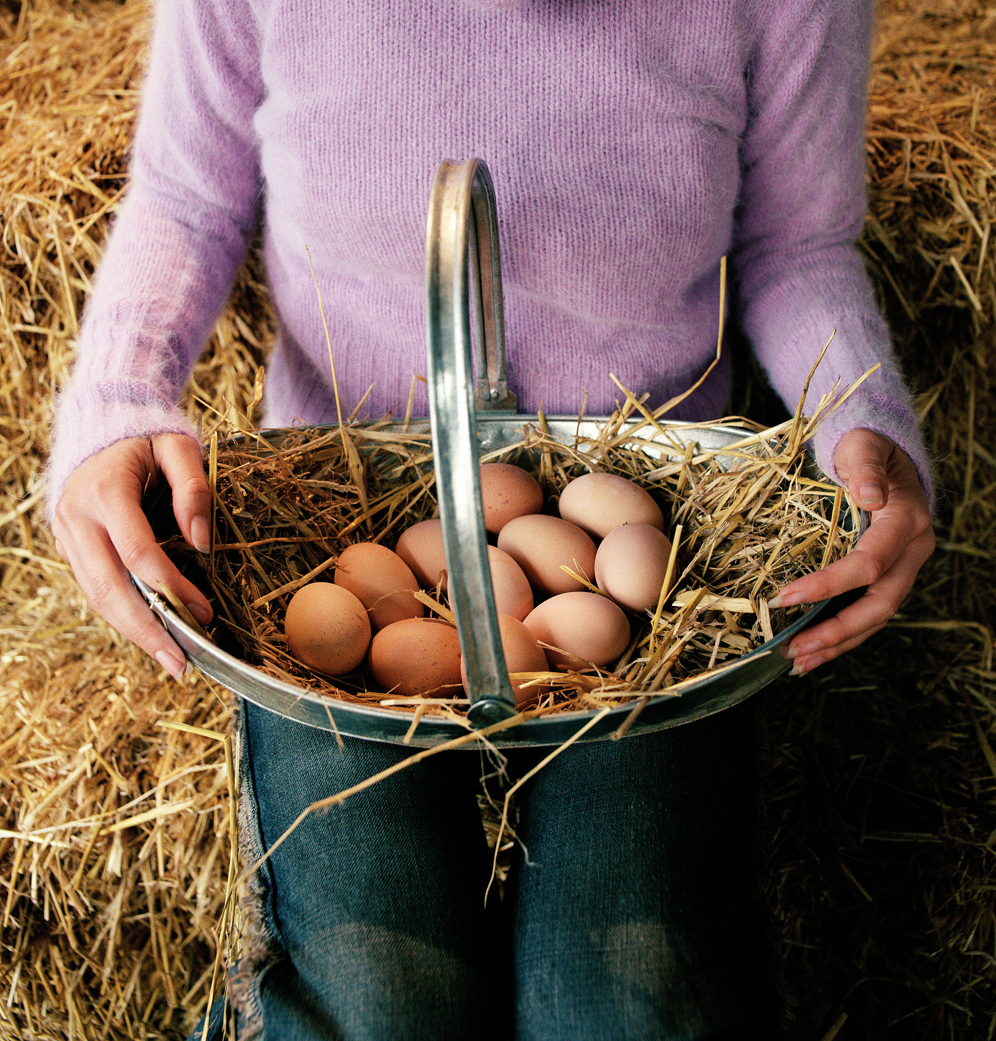 woman holding basket of eggs, mid section, close-up