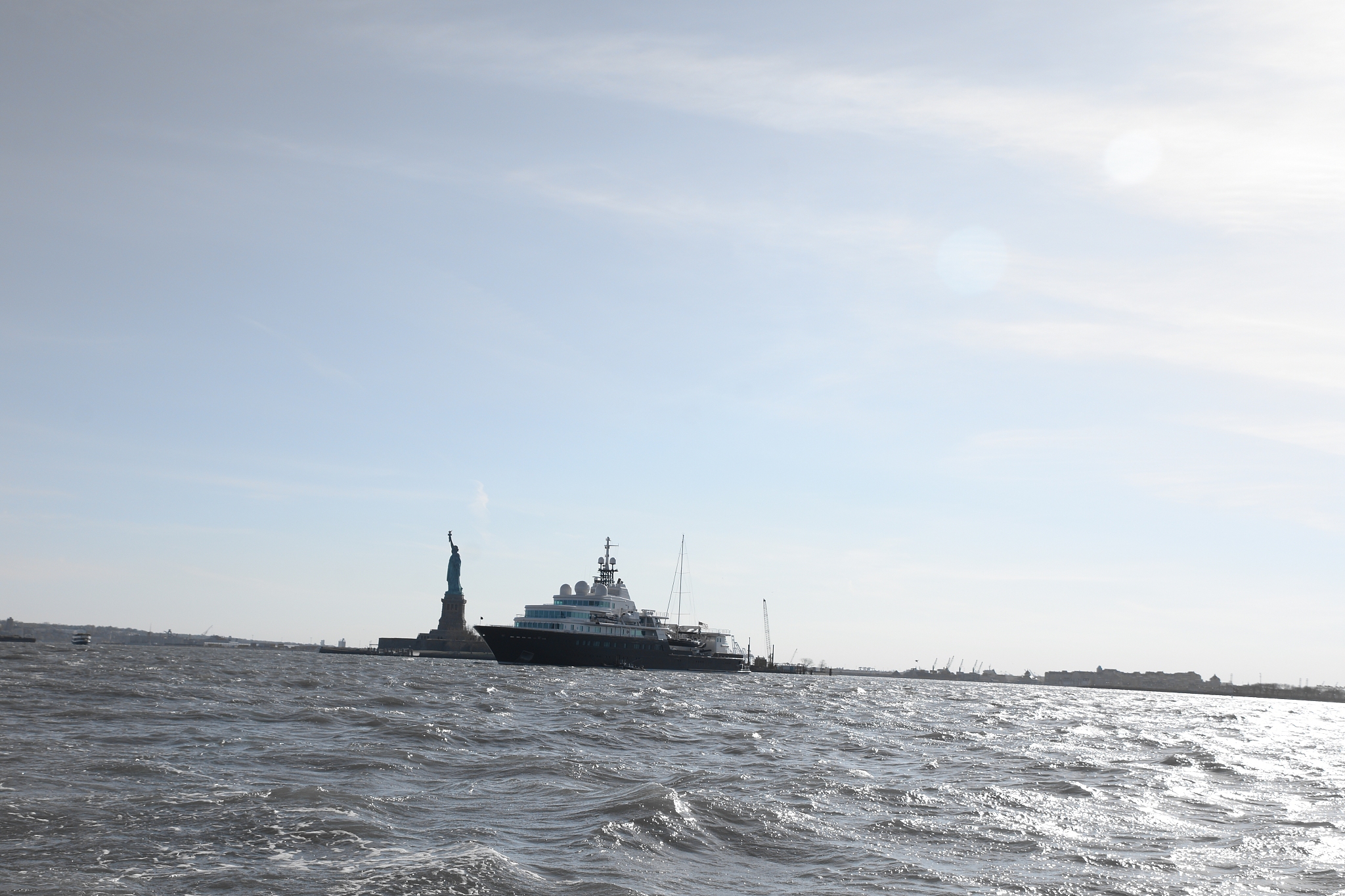 boat passing by statue of liberty