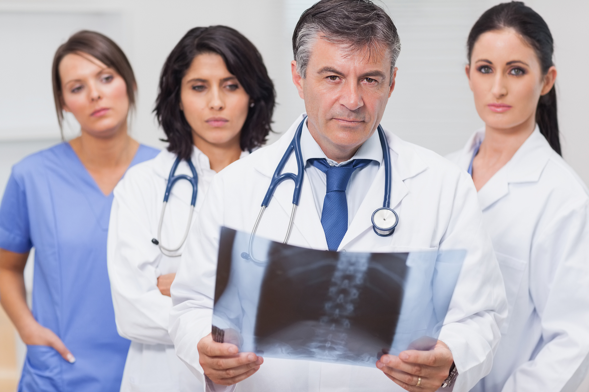 doctor holding xray with his team