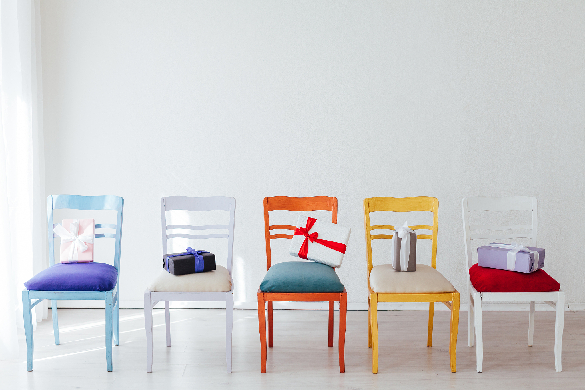 five vintage chairs with gifts in the white room