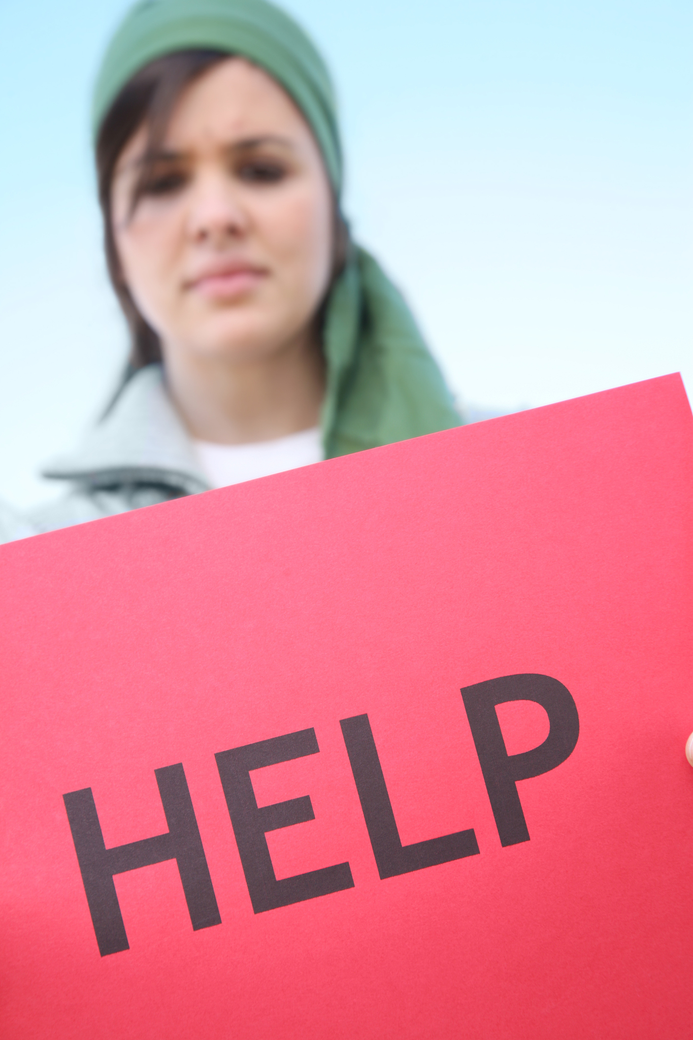 concerned young woman holds a help sign