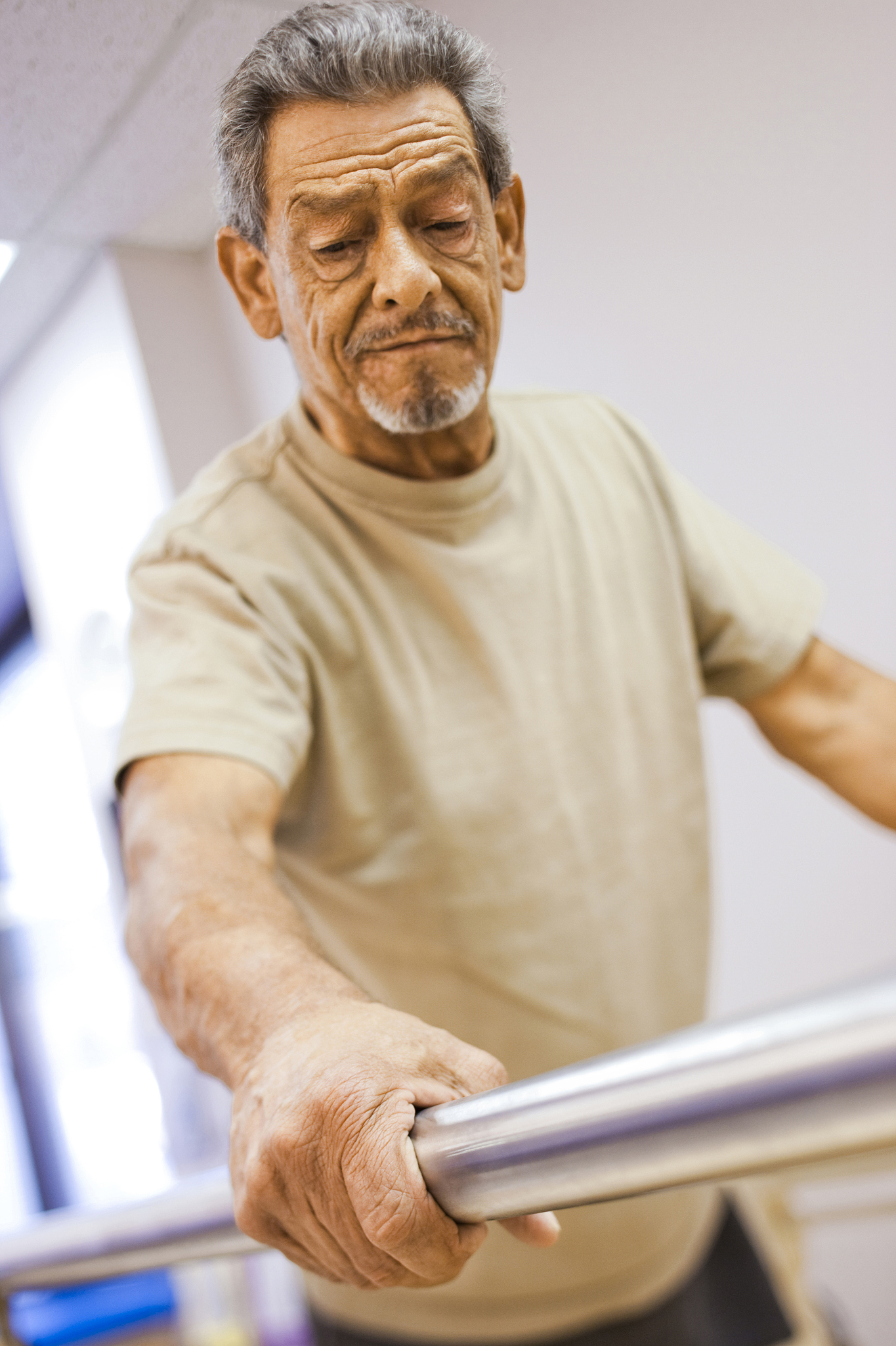 physical therapist assisting an older man with one leg in walkin