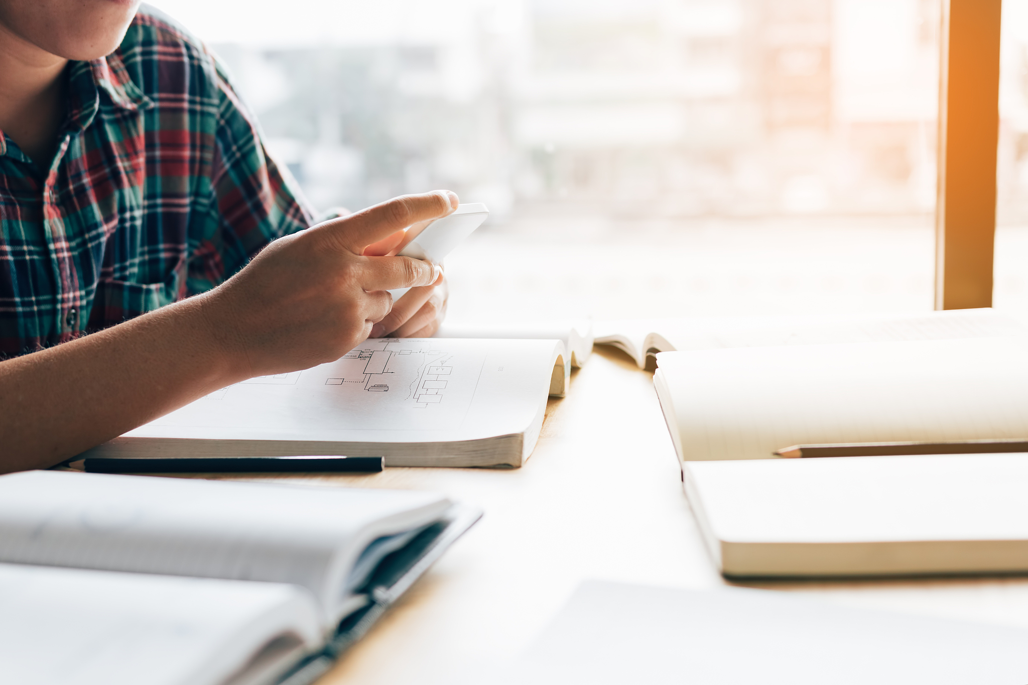 young student holding smartphone waiting to studying with friend