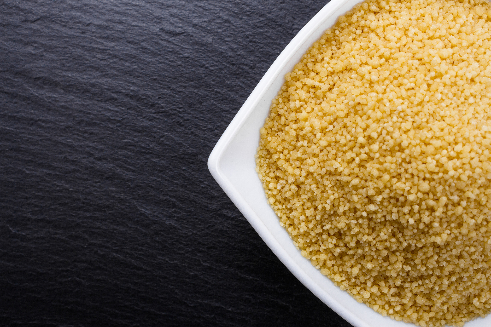 fresh couscous on a dark stone background