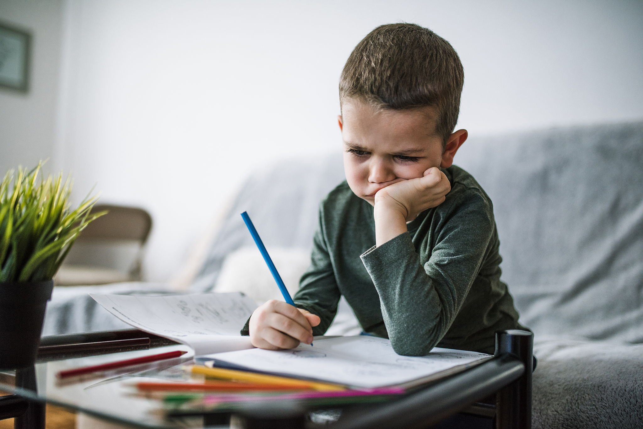 boy coloring at table stock photo