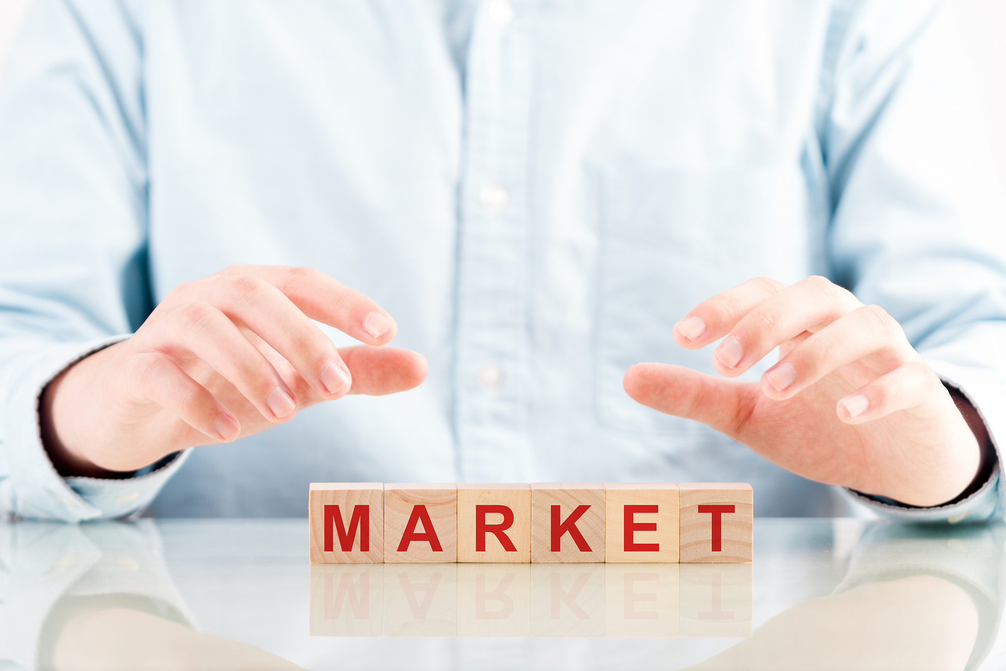 word 'market' on blocks under protective hands