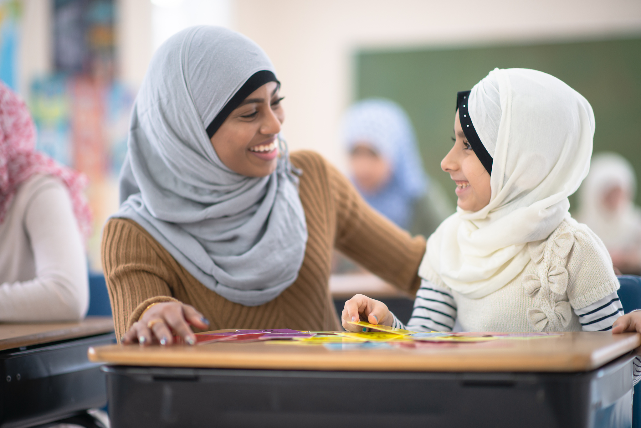 muslim teacher helping a student stock photo