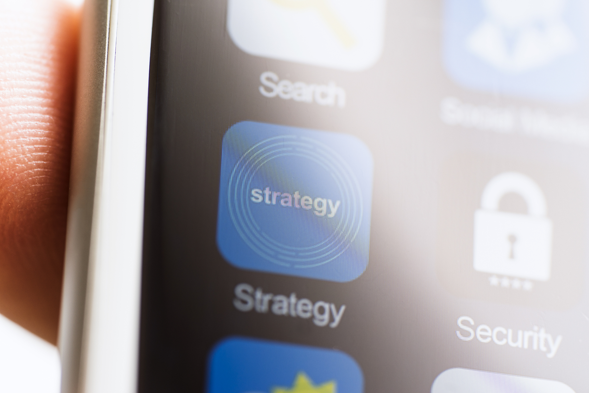 hand holding phone, strategy app on phone screen