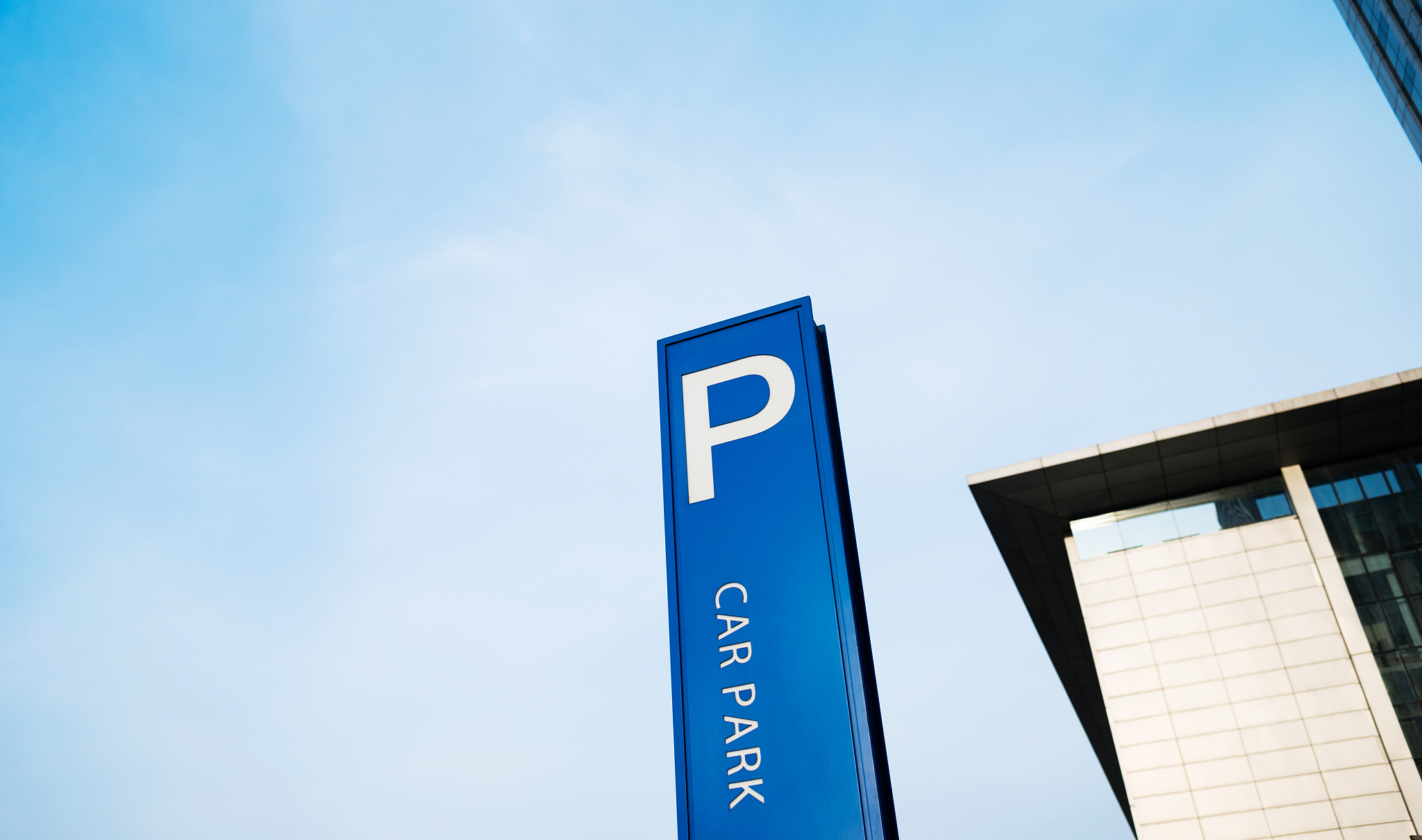 a blue parking sign beside the road
