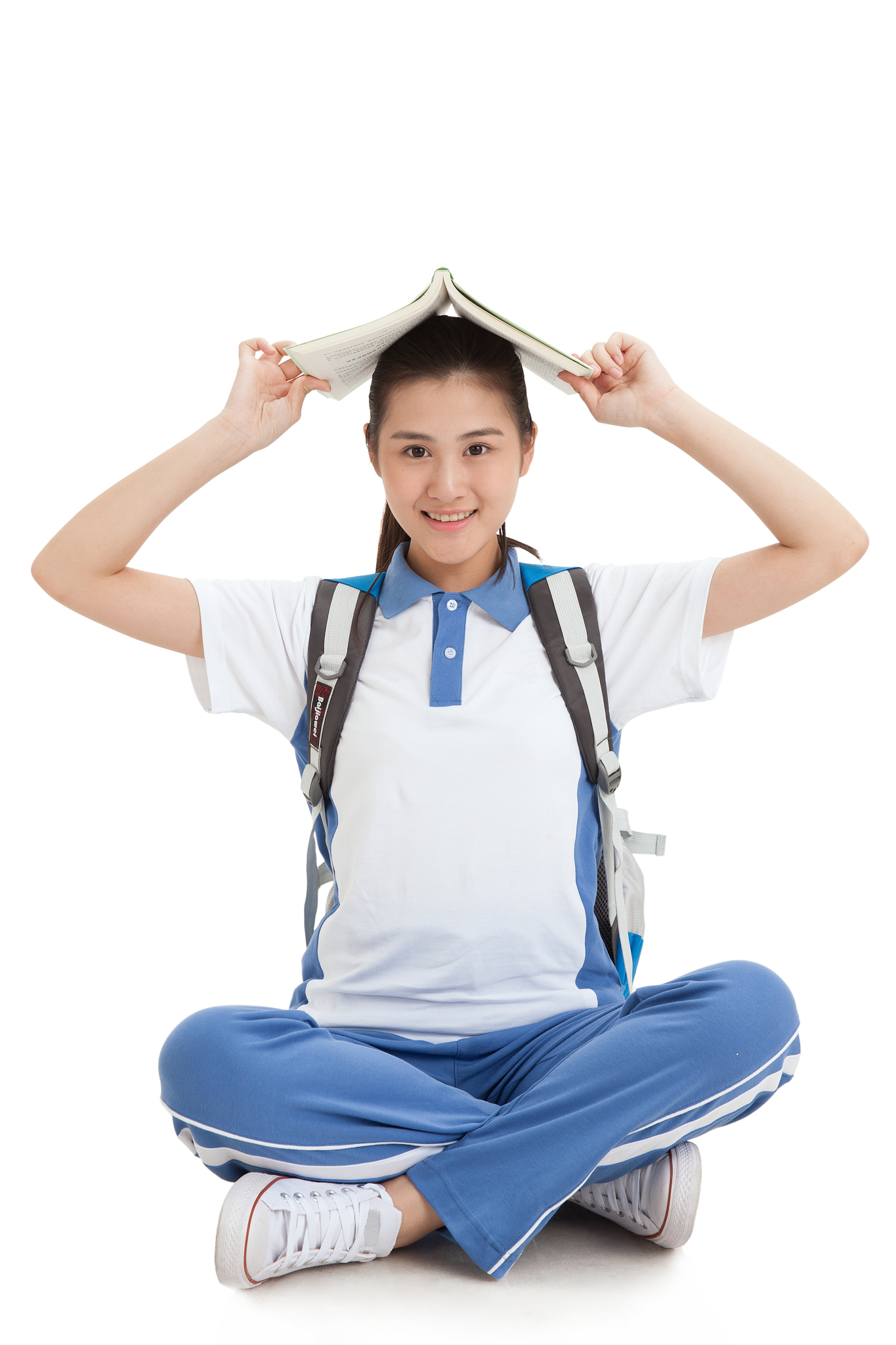 一个中学女生头顶着书坐在地上