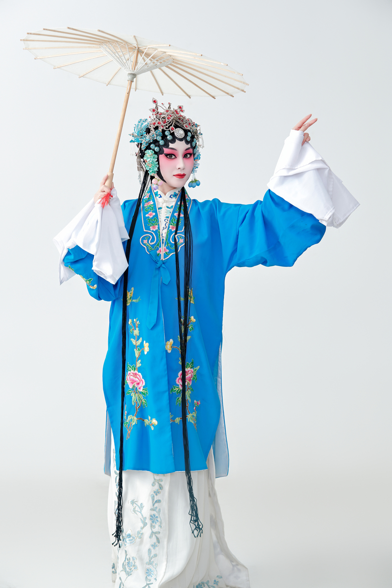 一位京剧女演员扮演青衣或花旦角色,手持油纸伞.