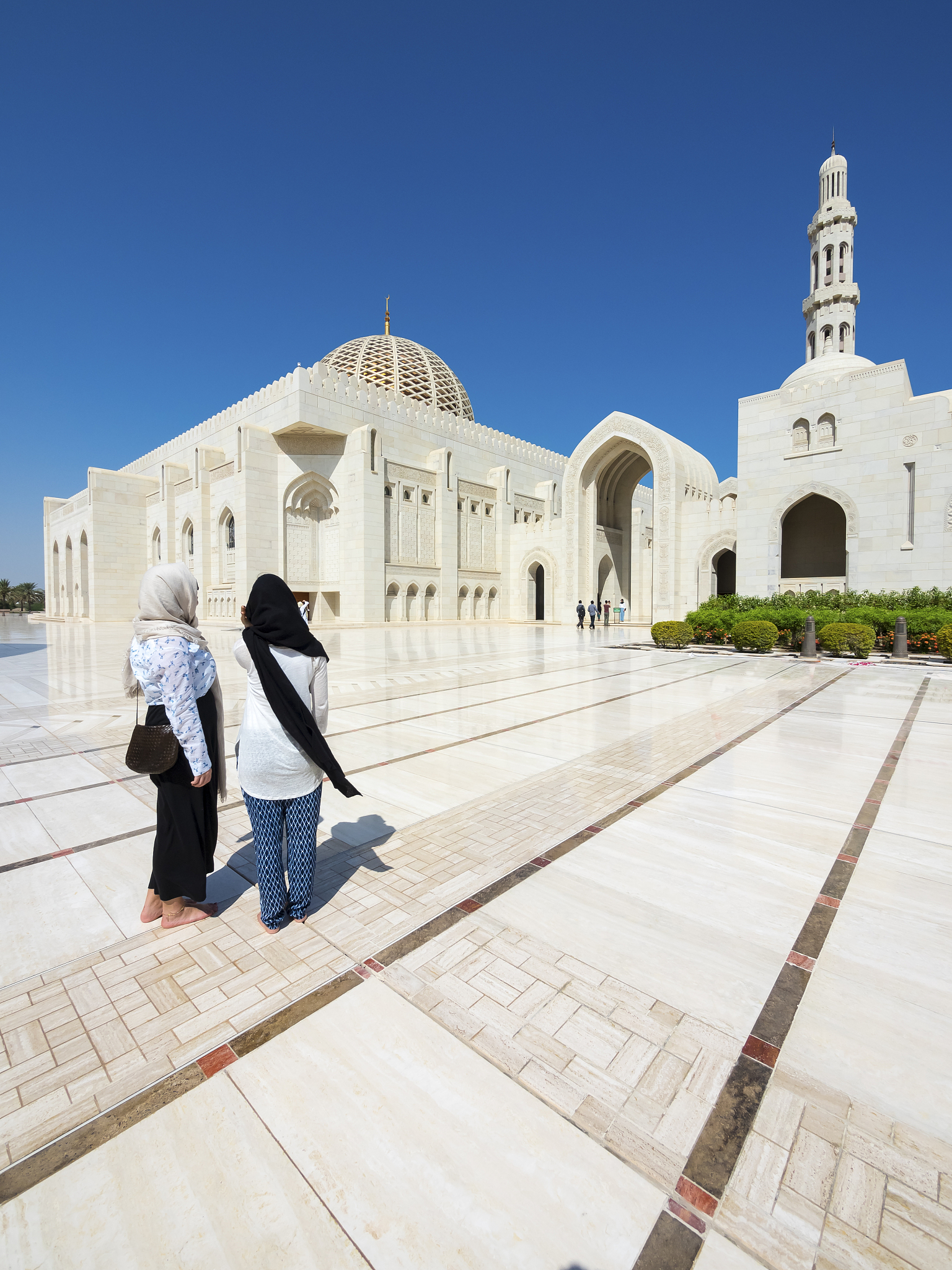 oman, muscat, sultan qaboos grand mosque, two female tourists wi