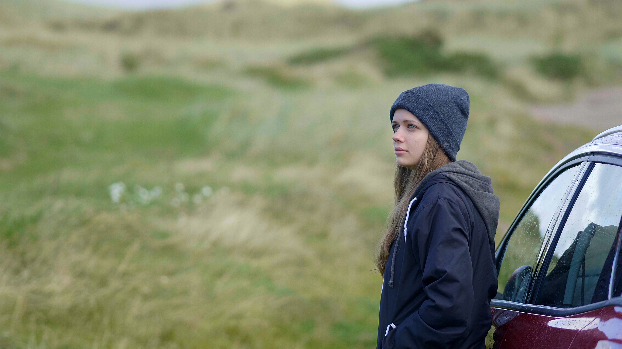 young woman steps out of her car and explores the surroundings