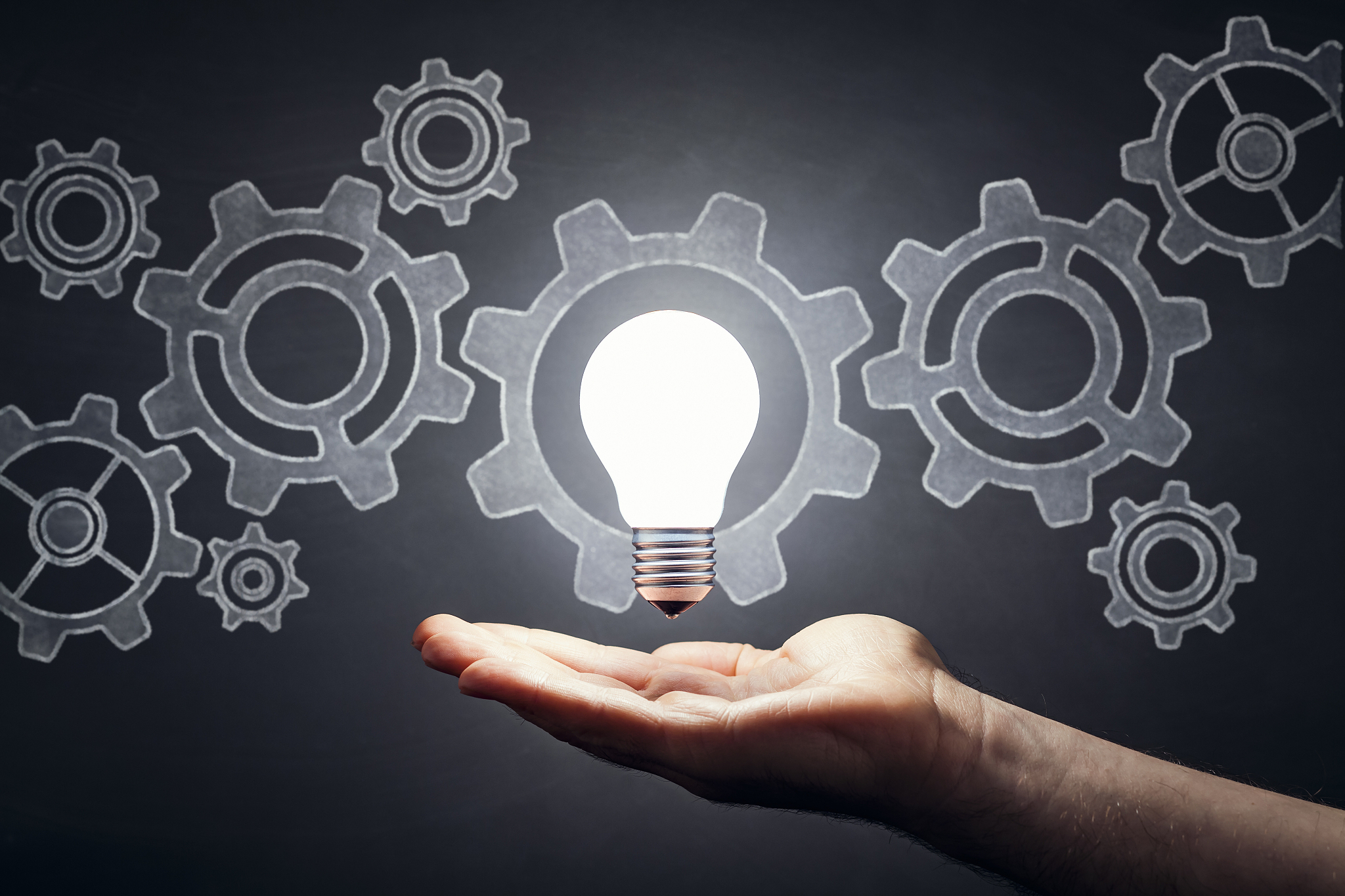 gears - light bulb hand idea blackboard