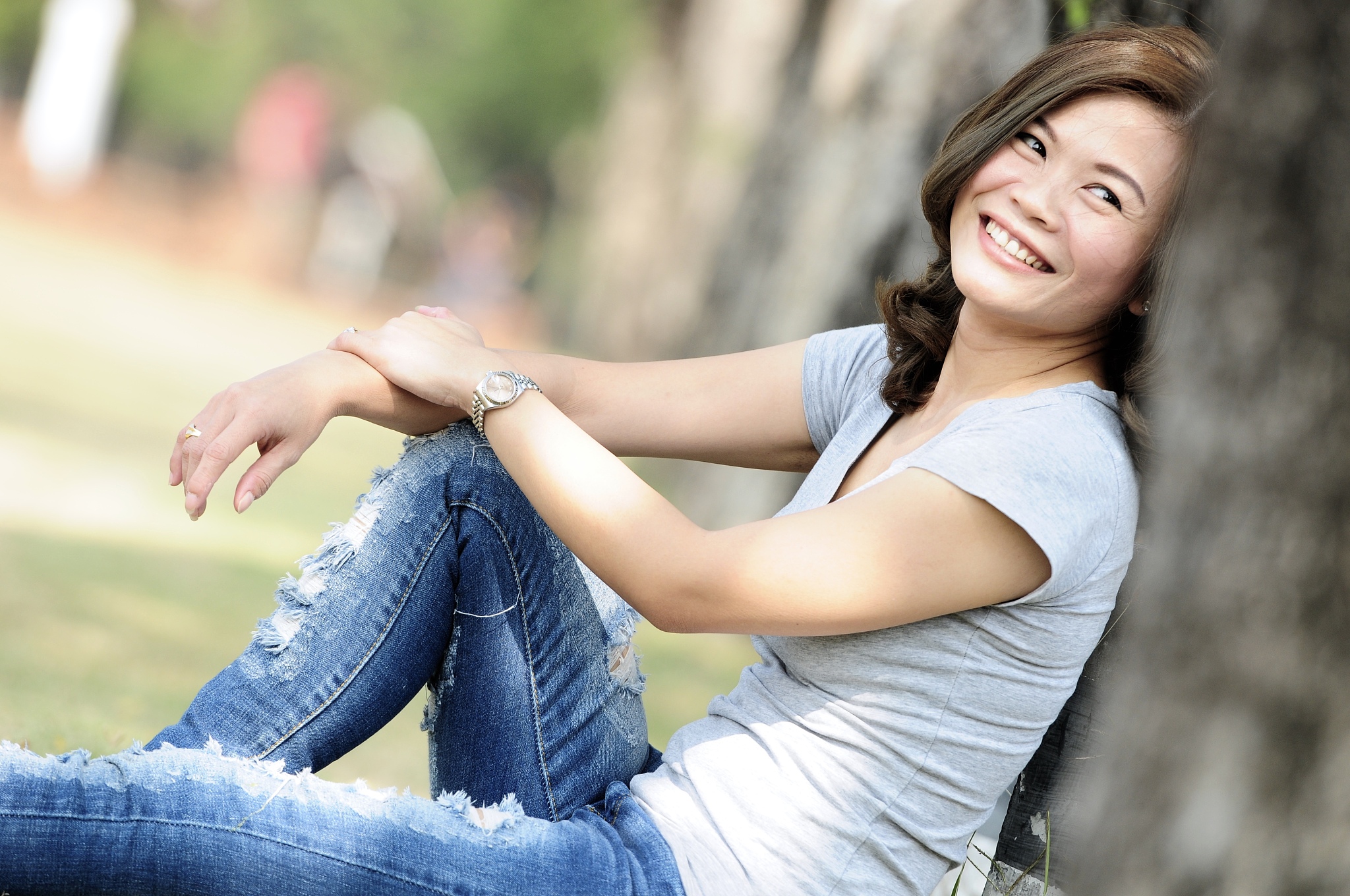 asian girl smiling and feeling happy in the park in a sunny summ