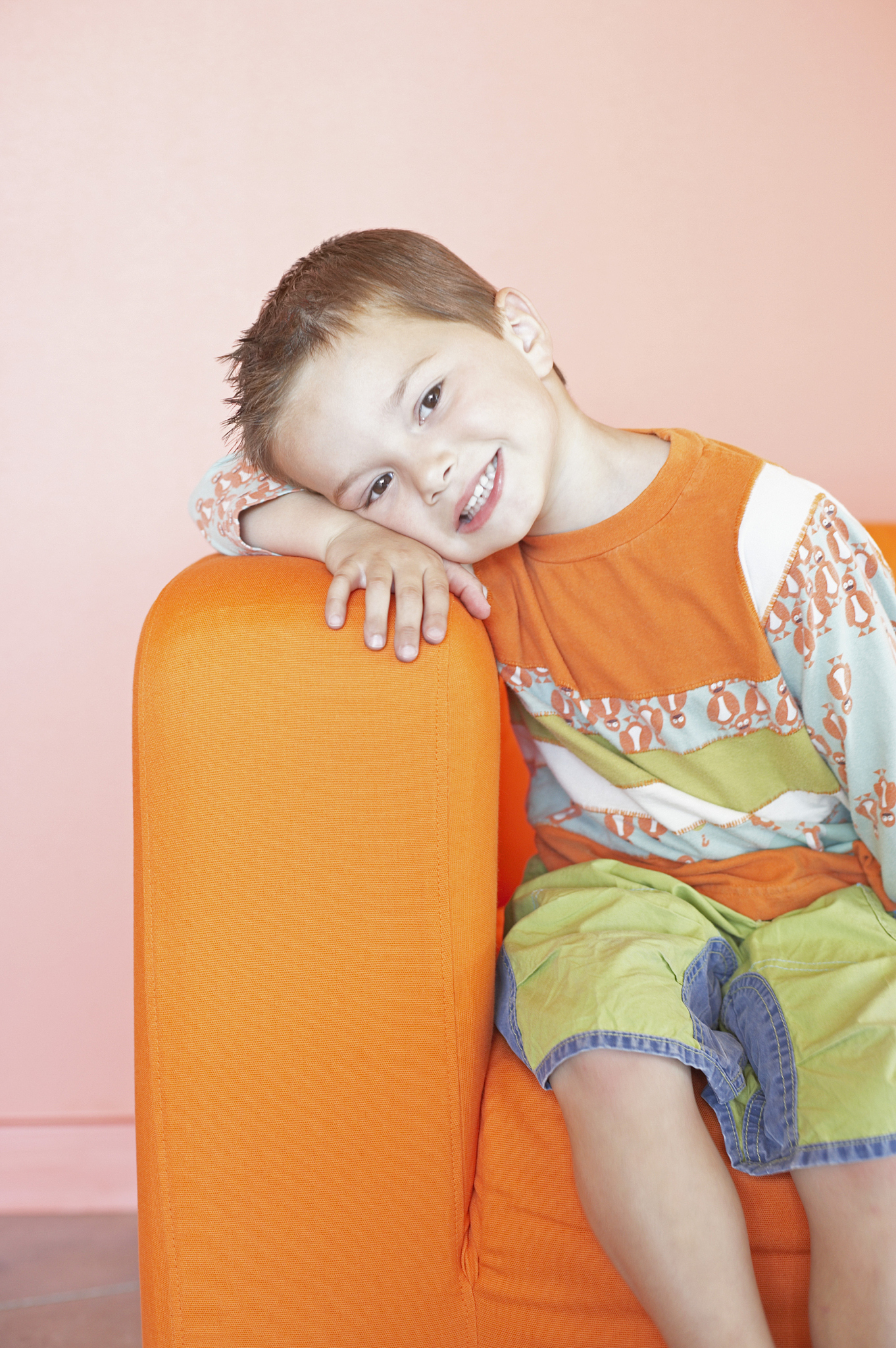 portrait of a boy leaning on the arm rest of a couch