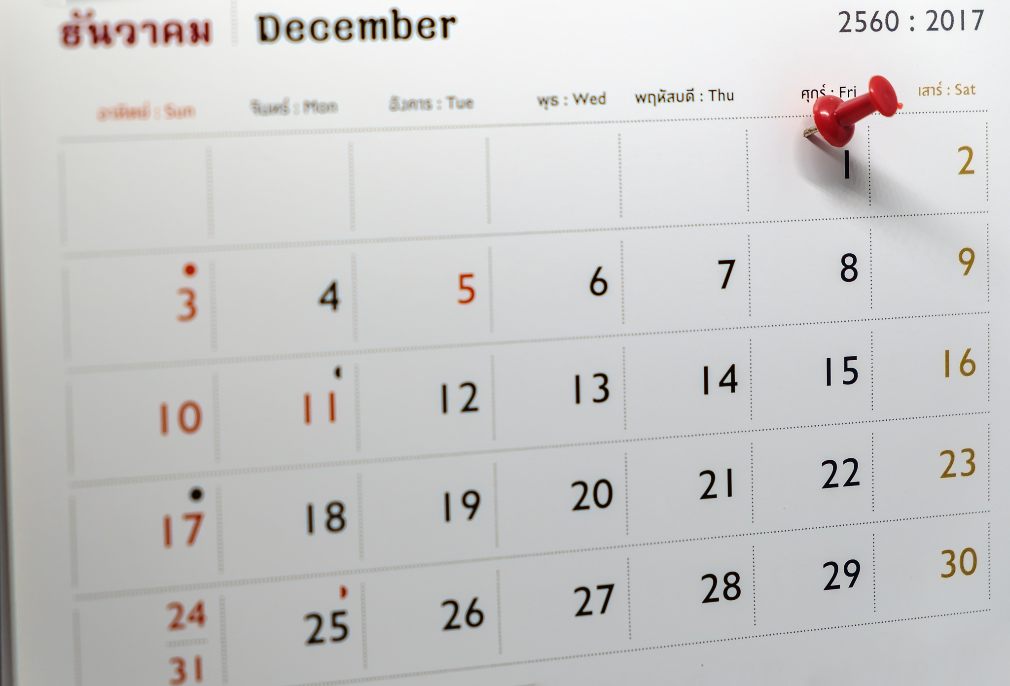 selective focus of a red push pin marking on calendar date on de