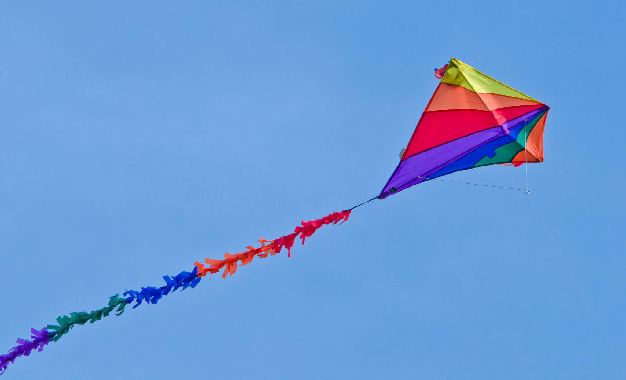a beautiful, colourful stunt kite, in the blue sky, high up in t