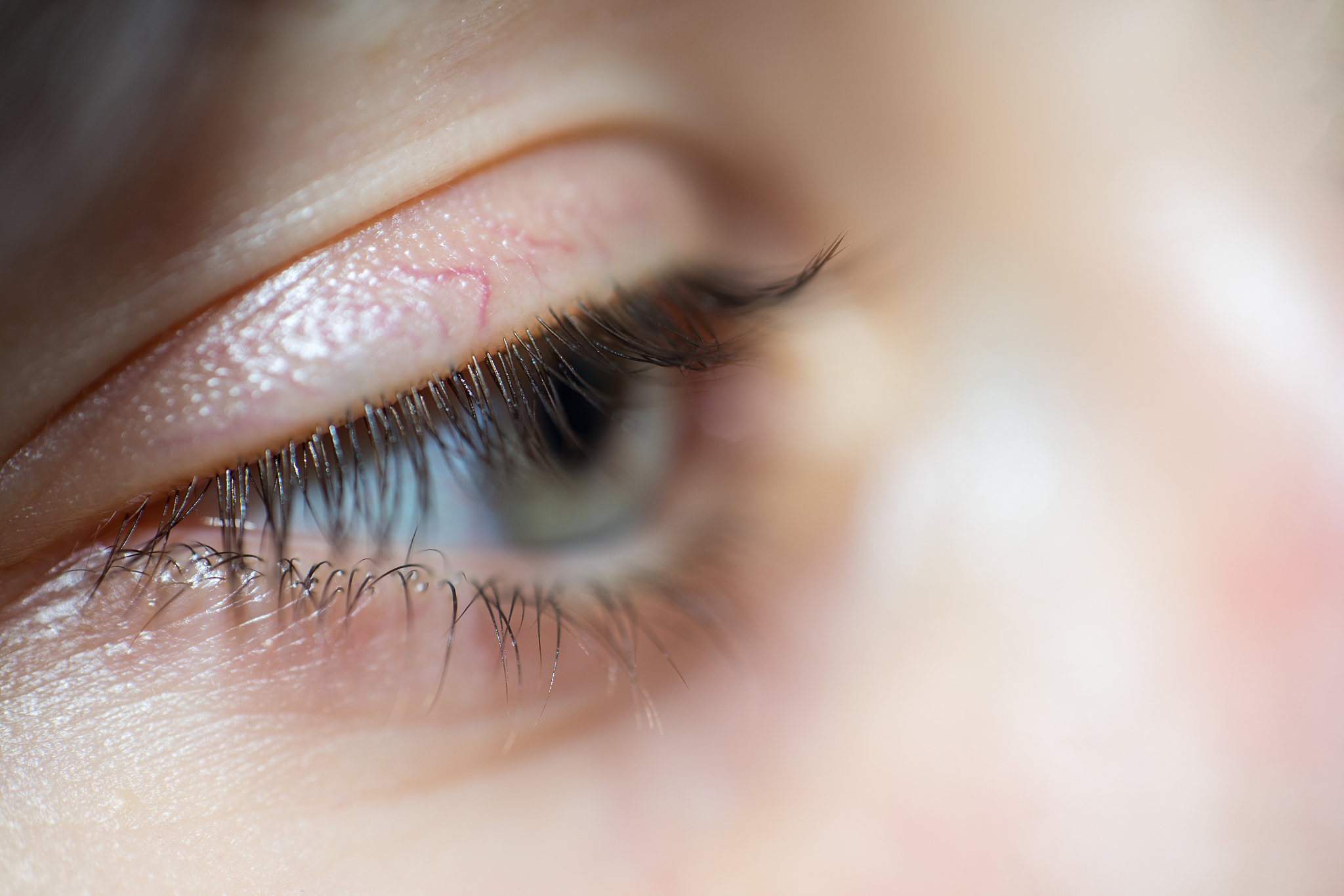 close-up of woman with blue eyes and long eyelashes looking away