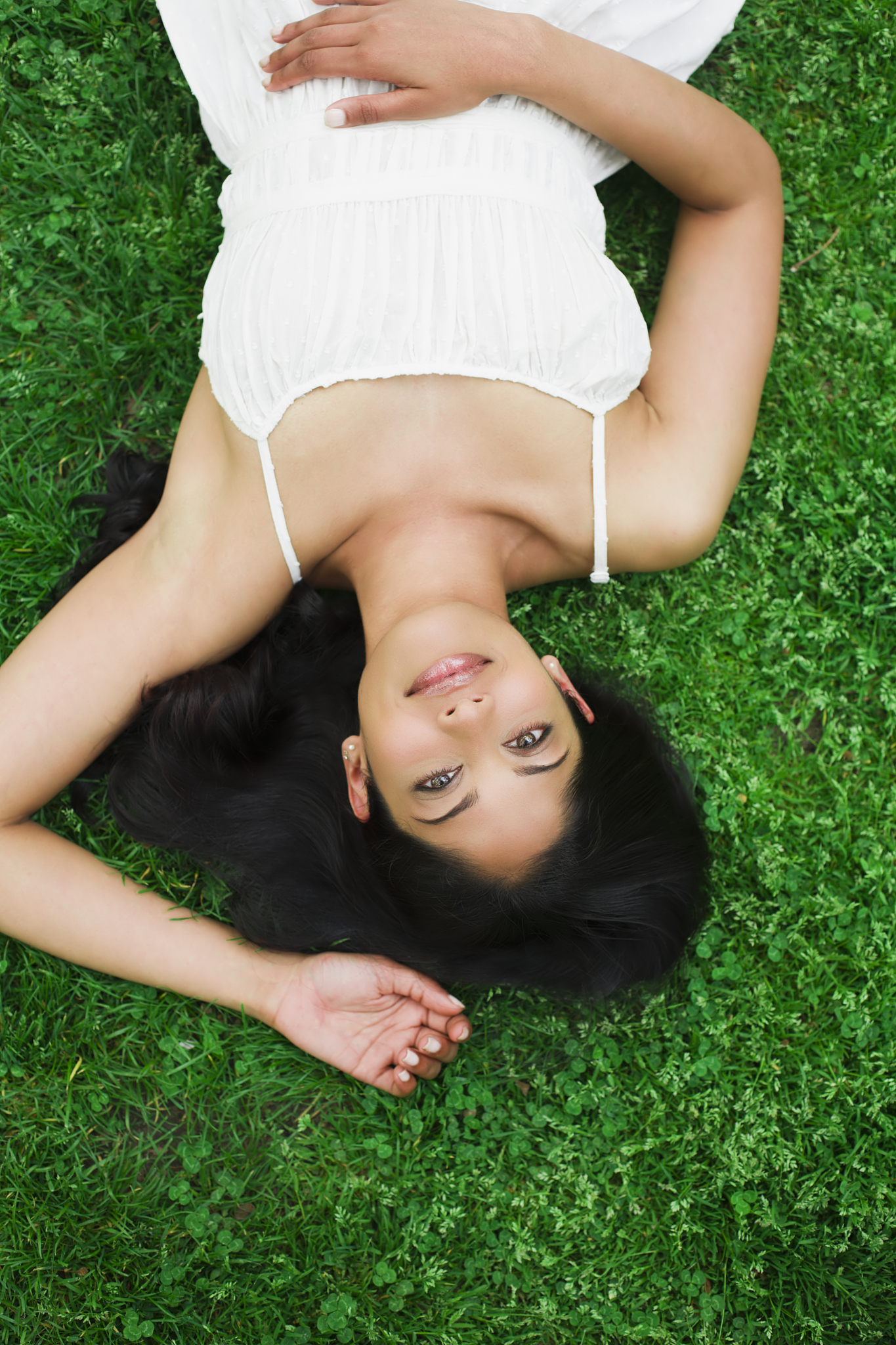 young woman lying on grass, elevated view, portrait