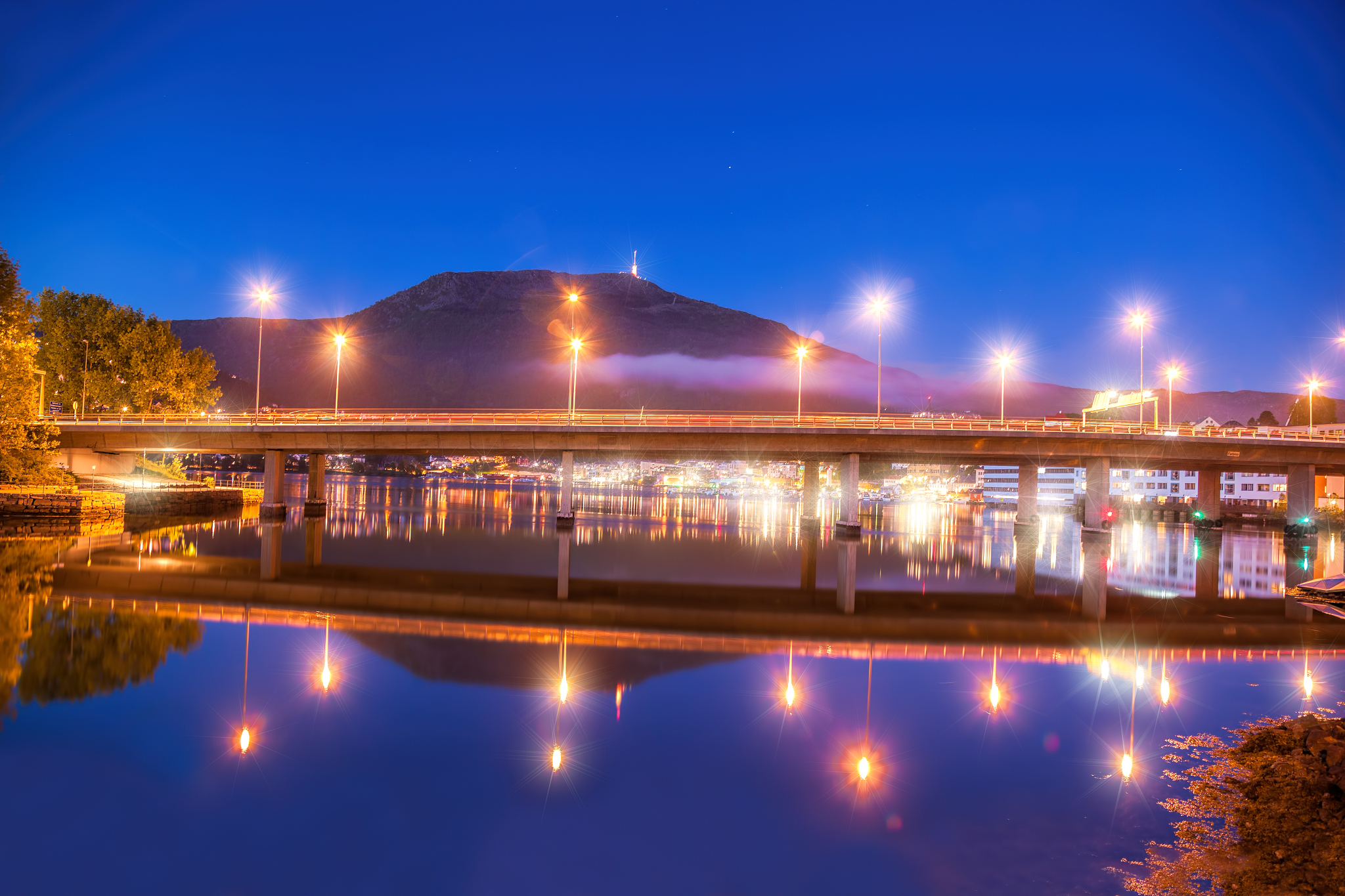 bridge at night against mount ulriken in bergen, norway
