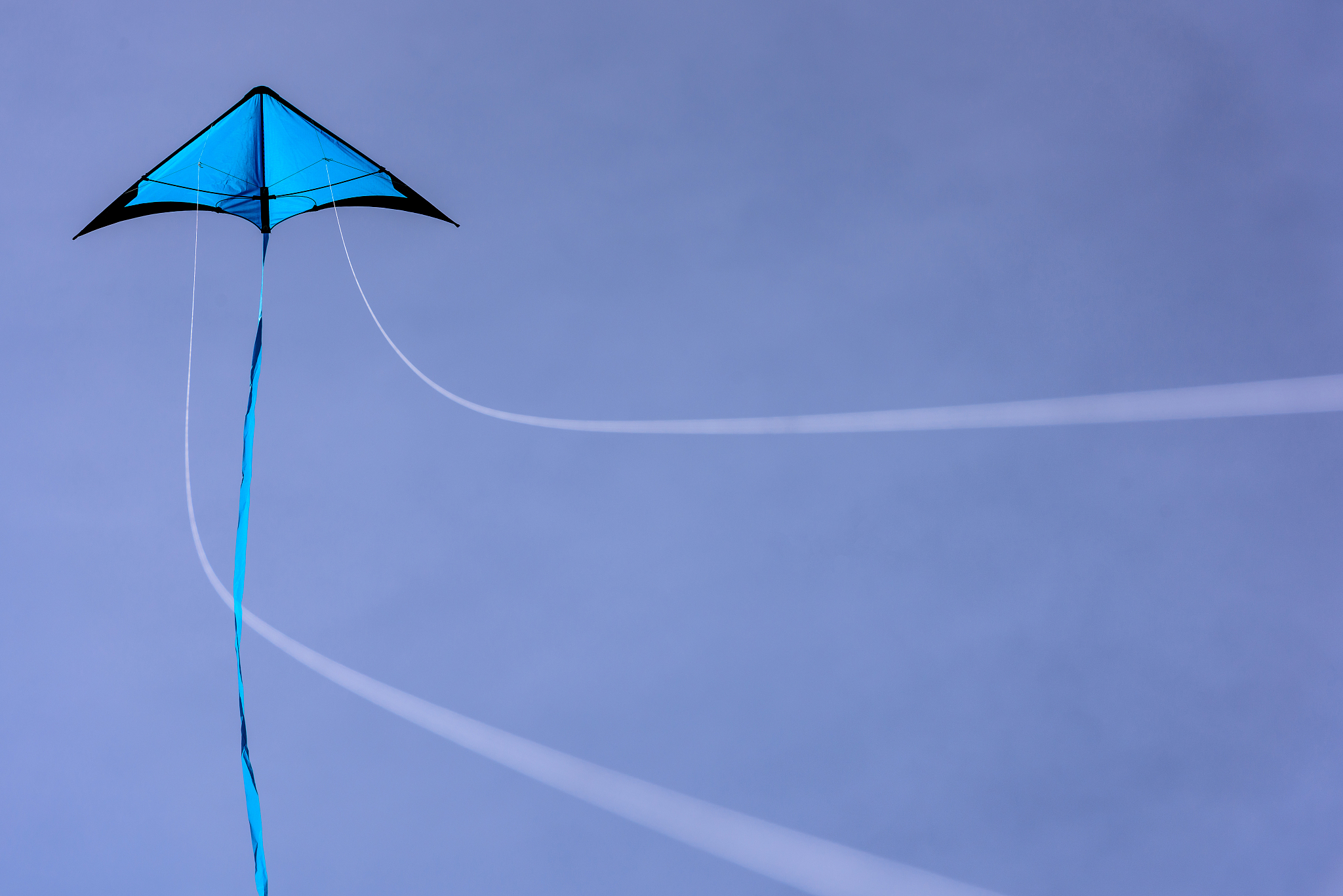 blue kite floating in the blue sky.