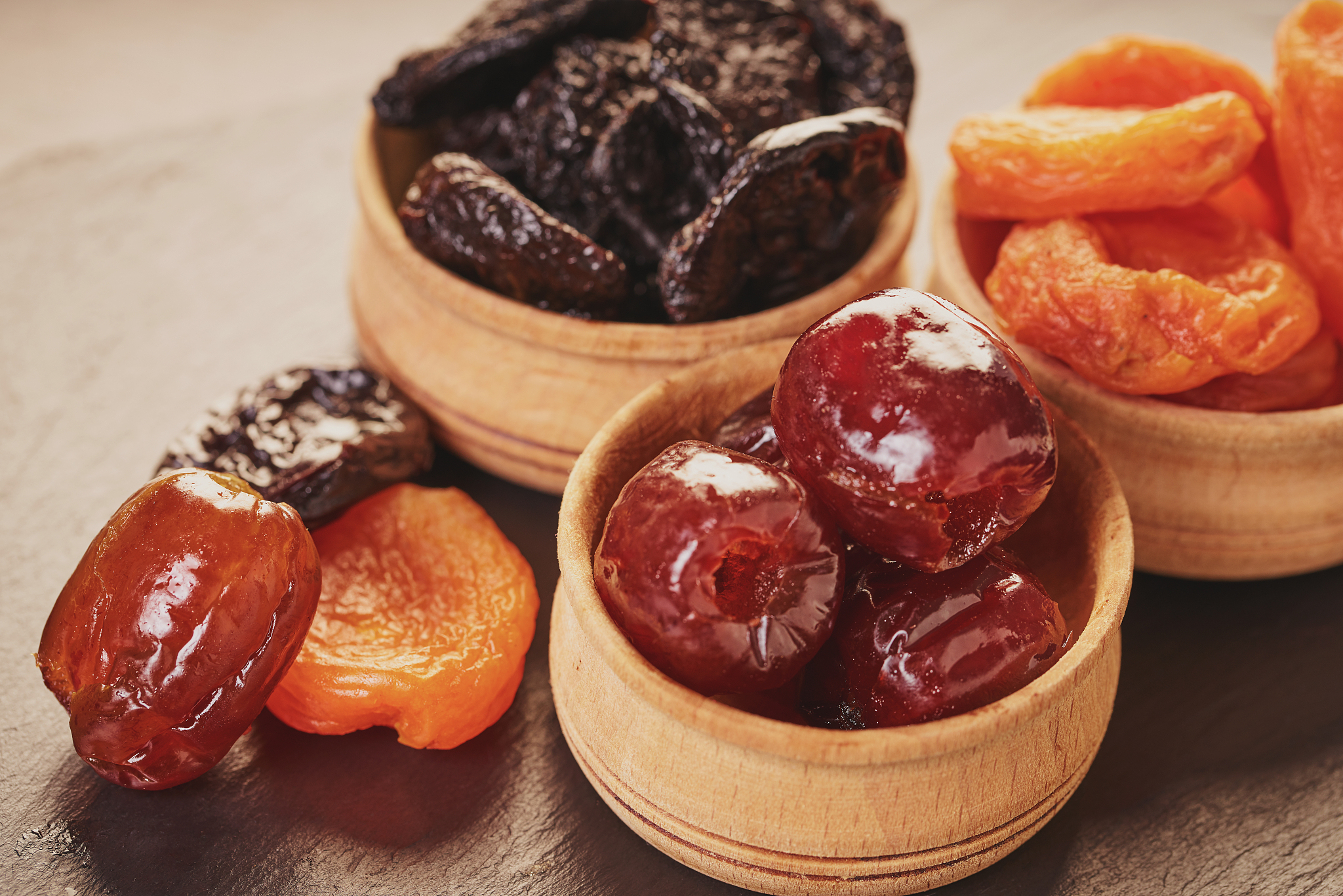 assorted dried fruits in wooden bowls
