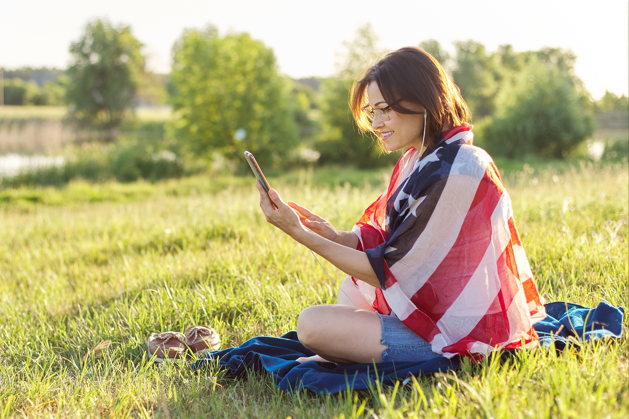 adult woman sitting on july evening in nature with usa flag scar