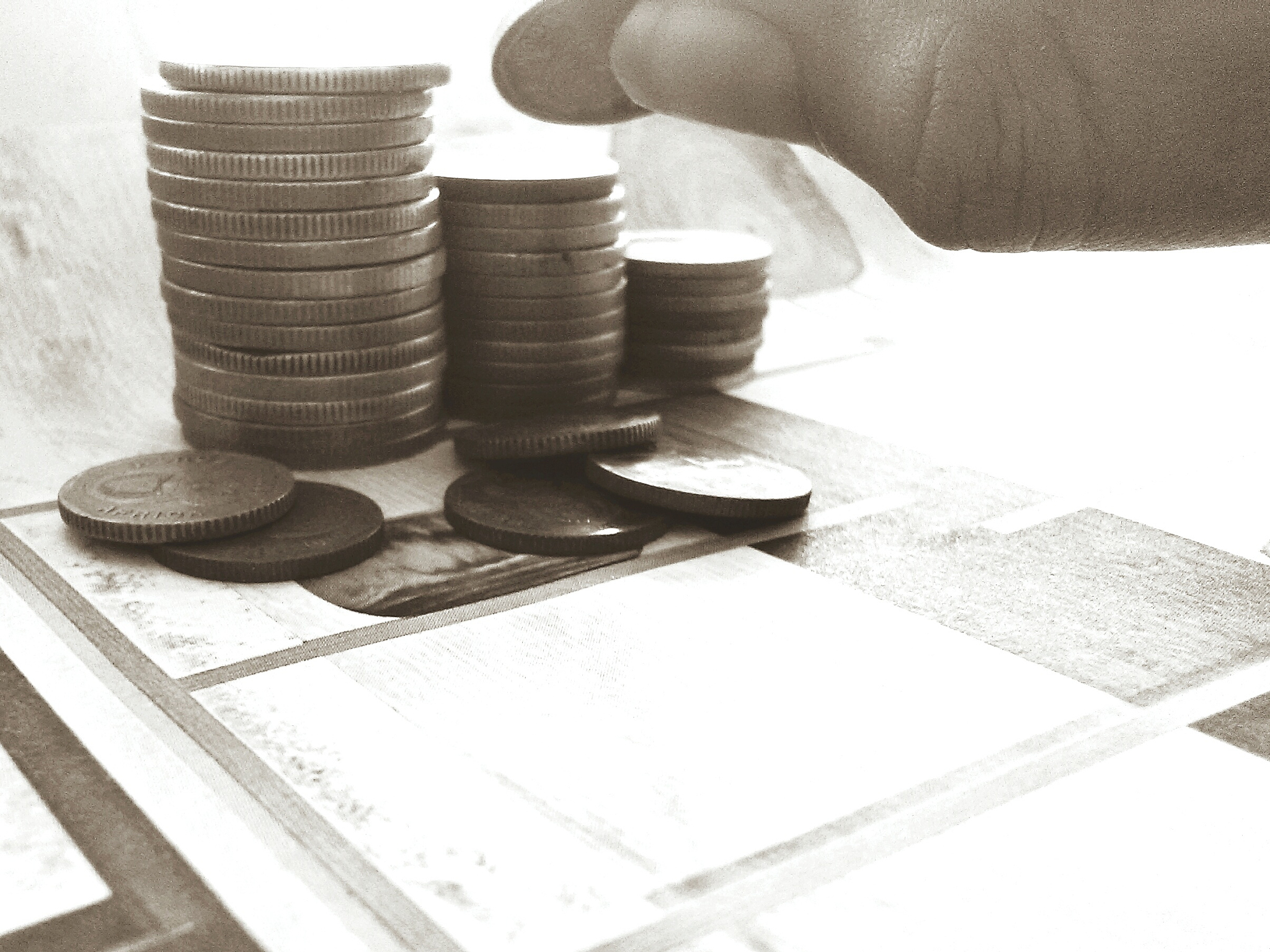 cropped hand stacking coins at table