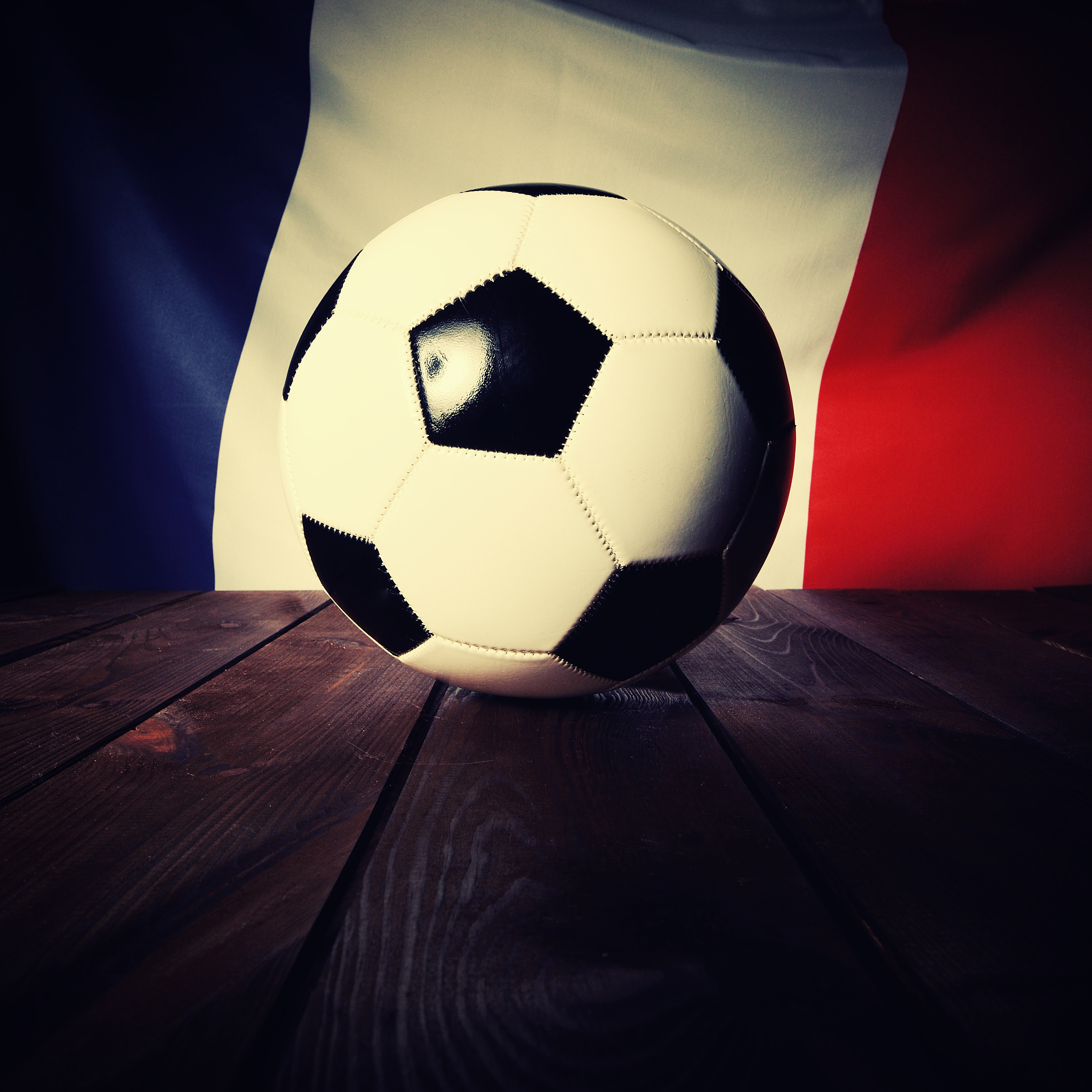 flag of france with football on wooden boards as background.
