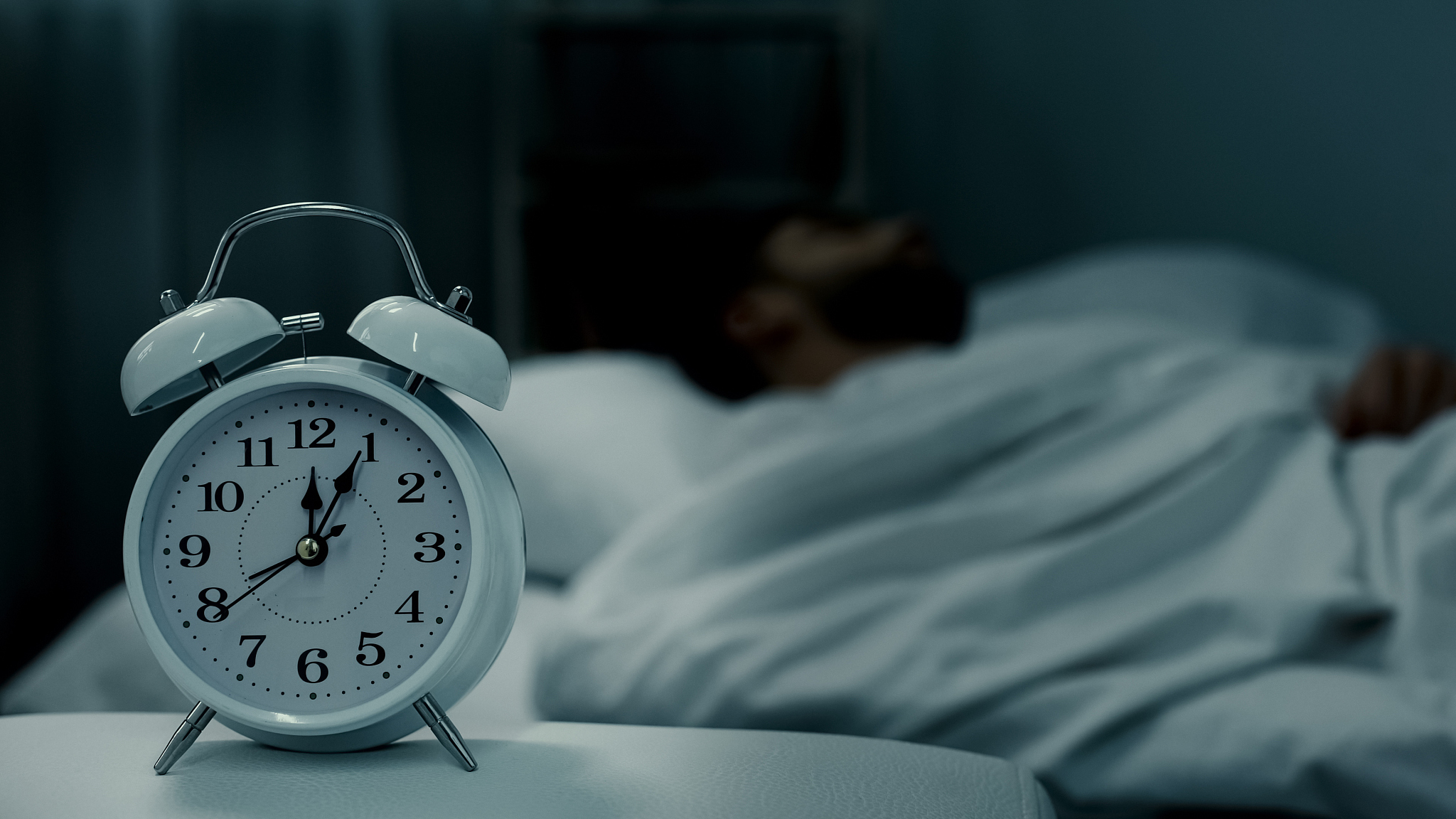man sleeping in bed, alarm clock showing midnight, rest hours, h