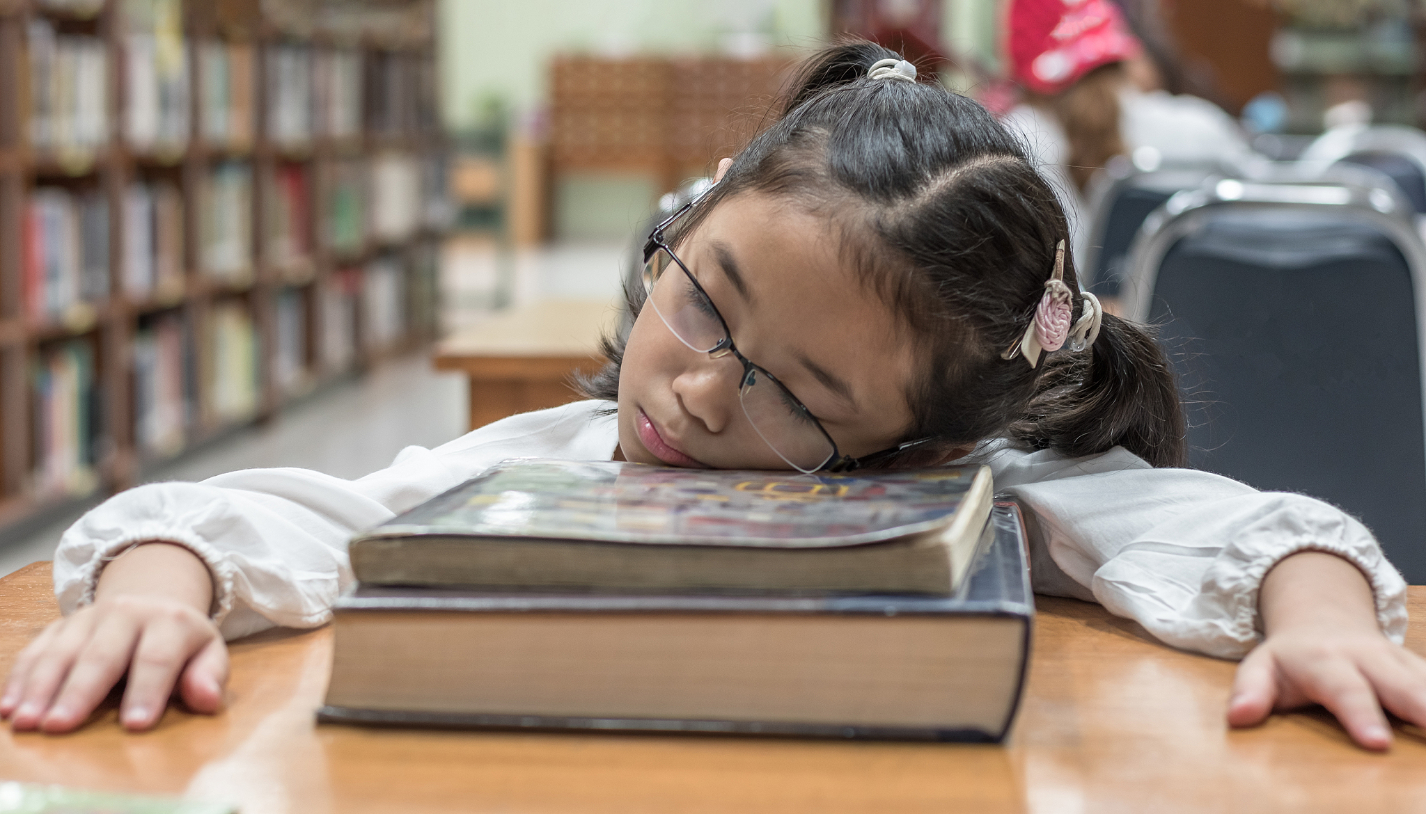 school student fall asleep while reading book in library or clas
