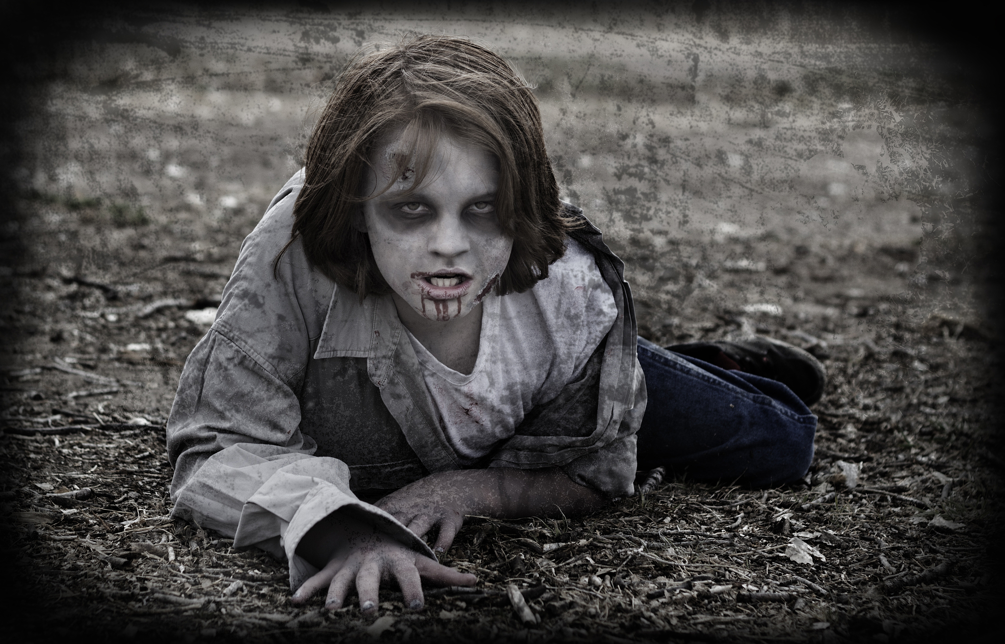 portrait of teenage boy with make-up lying on land