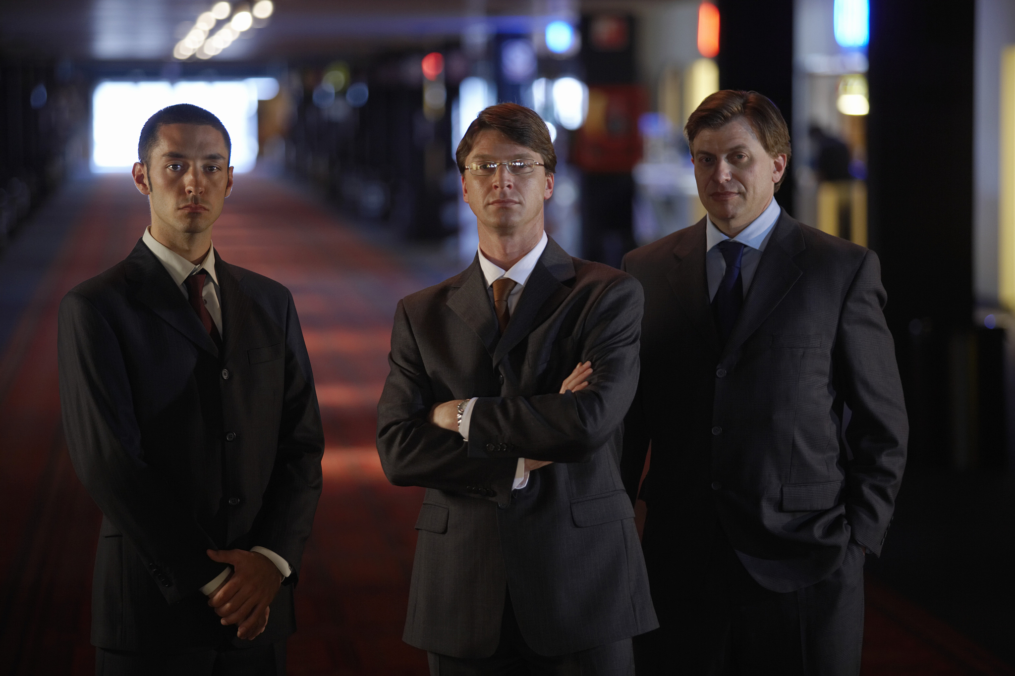 three businessmen, one with arms crossed, portrait