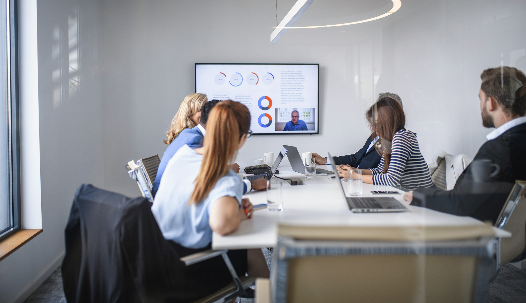 ceo video conferencing with executive team in board room