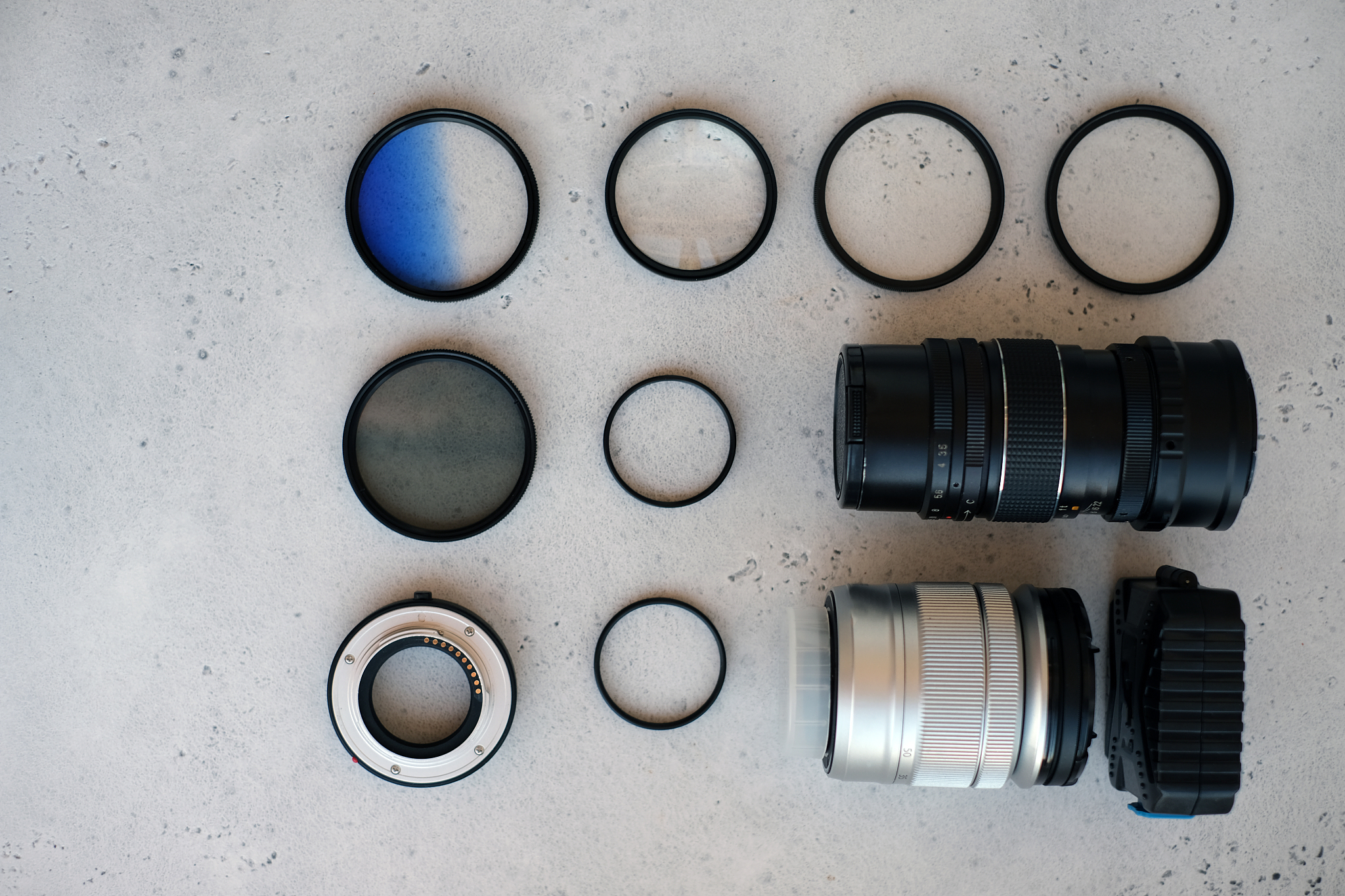 two lenses and filters to them, adapter rings and a box with fla
