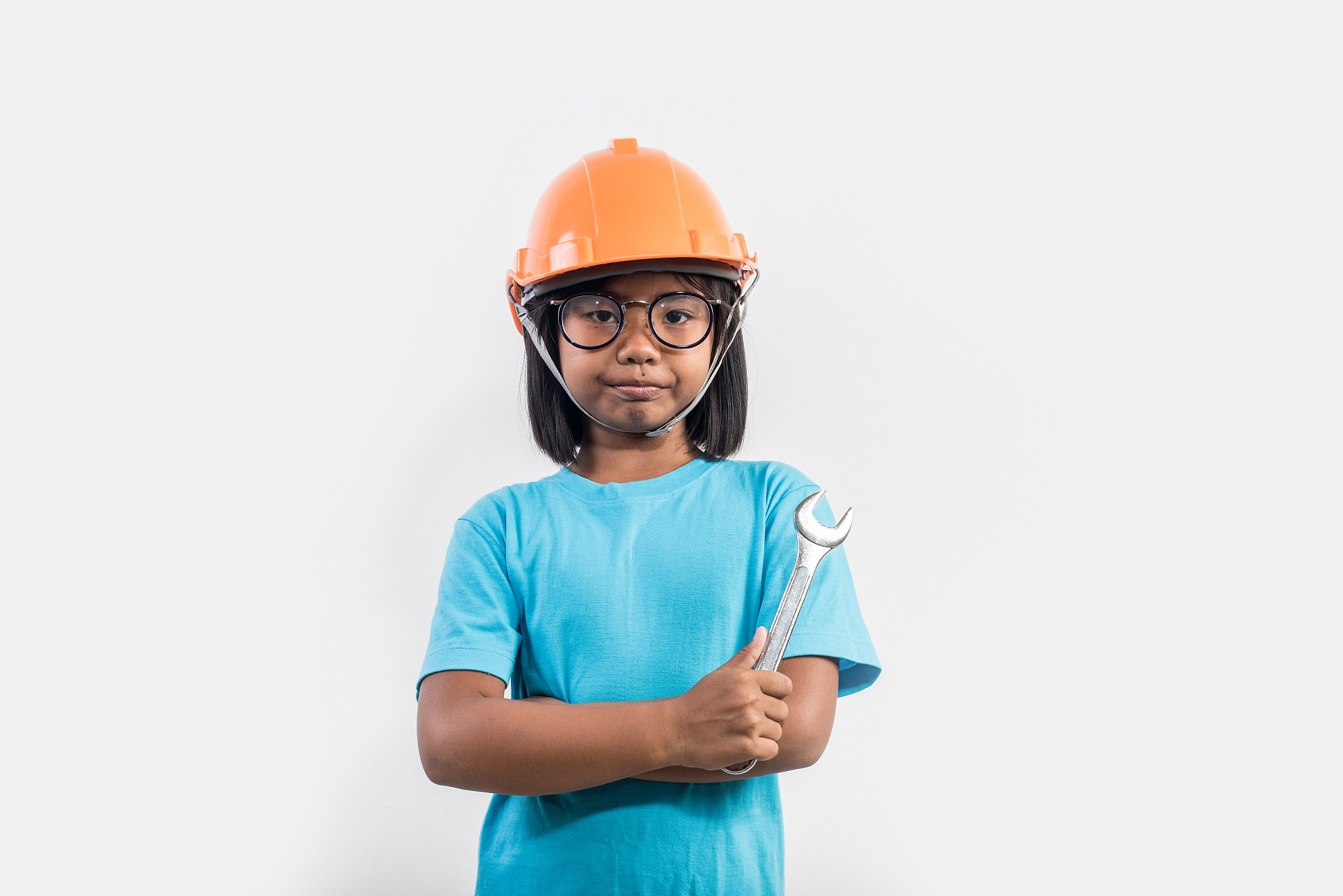 little girl wearing orange helmet in studio shot