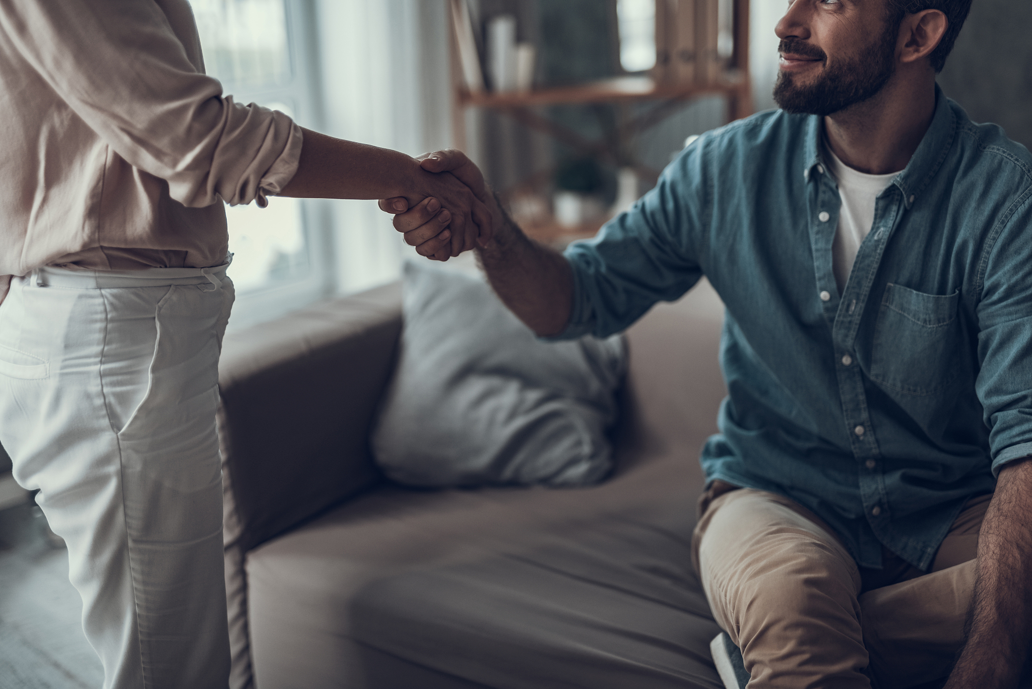 close up of smiling man shaking hands with friend