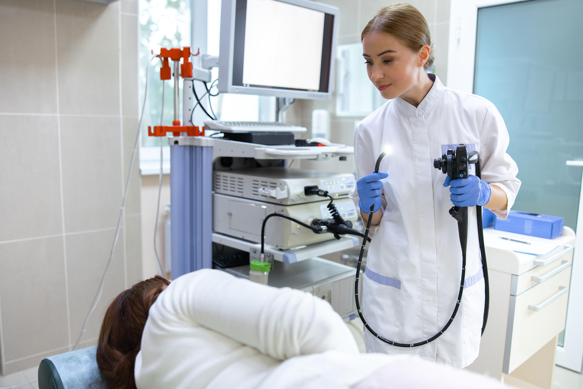 young woman examining patient with digital machine stock photo