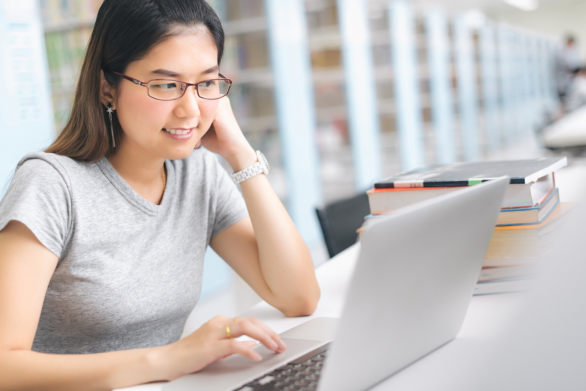 asia<strong>n</strong> woman using laptop in the library.'n