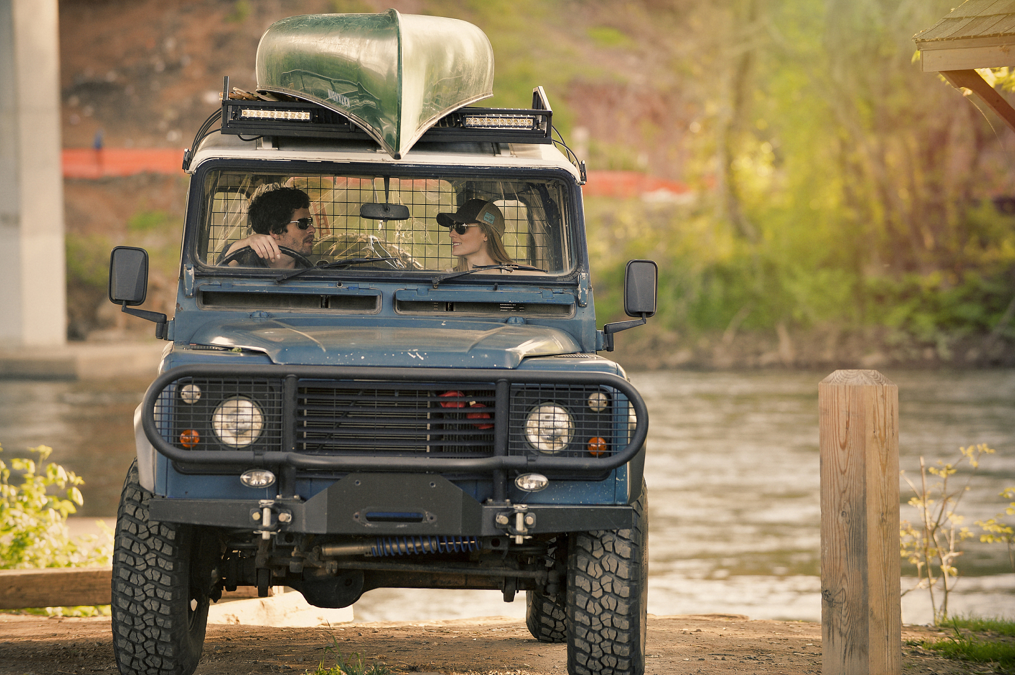 young couple unloading and canoeing during sunset