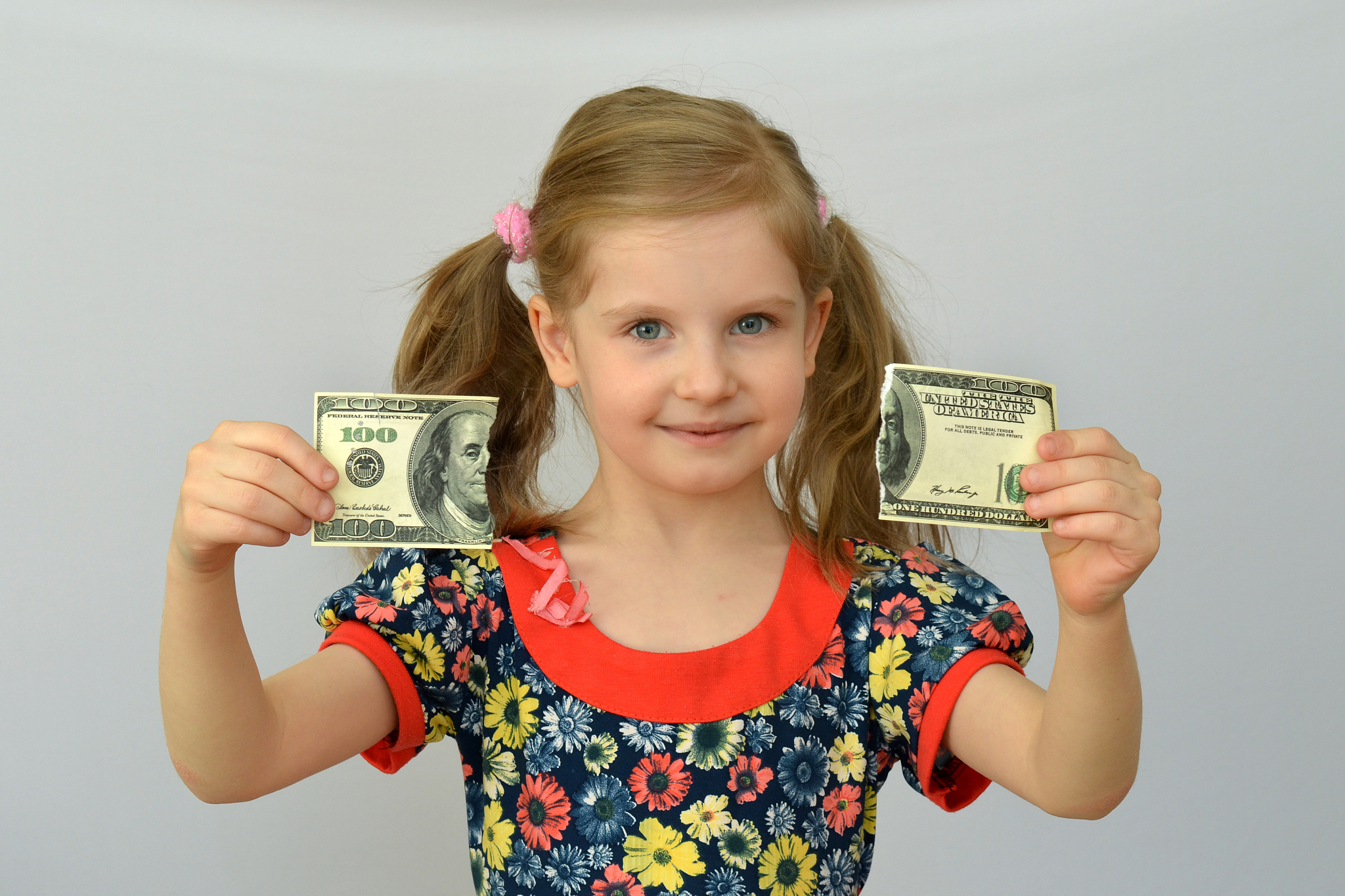 baby girl holds in hands a torn banknote ,dollar ,banking crisis