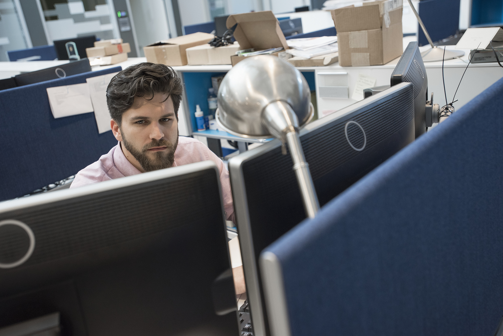 man working on computer in office, monitors in foreground