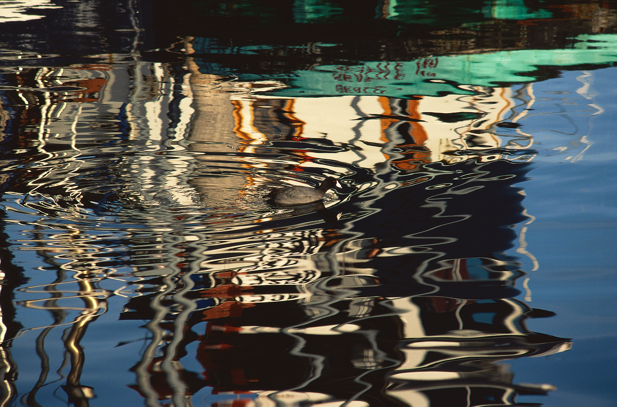 fishing boats reflecting on water surface in harbor