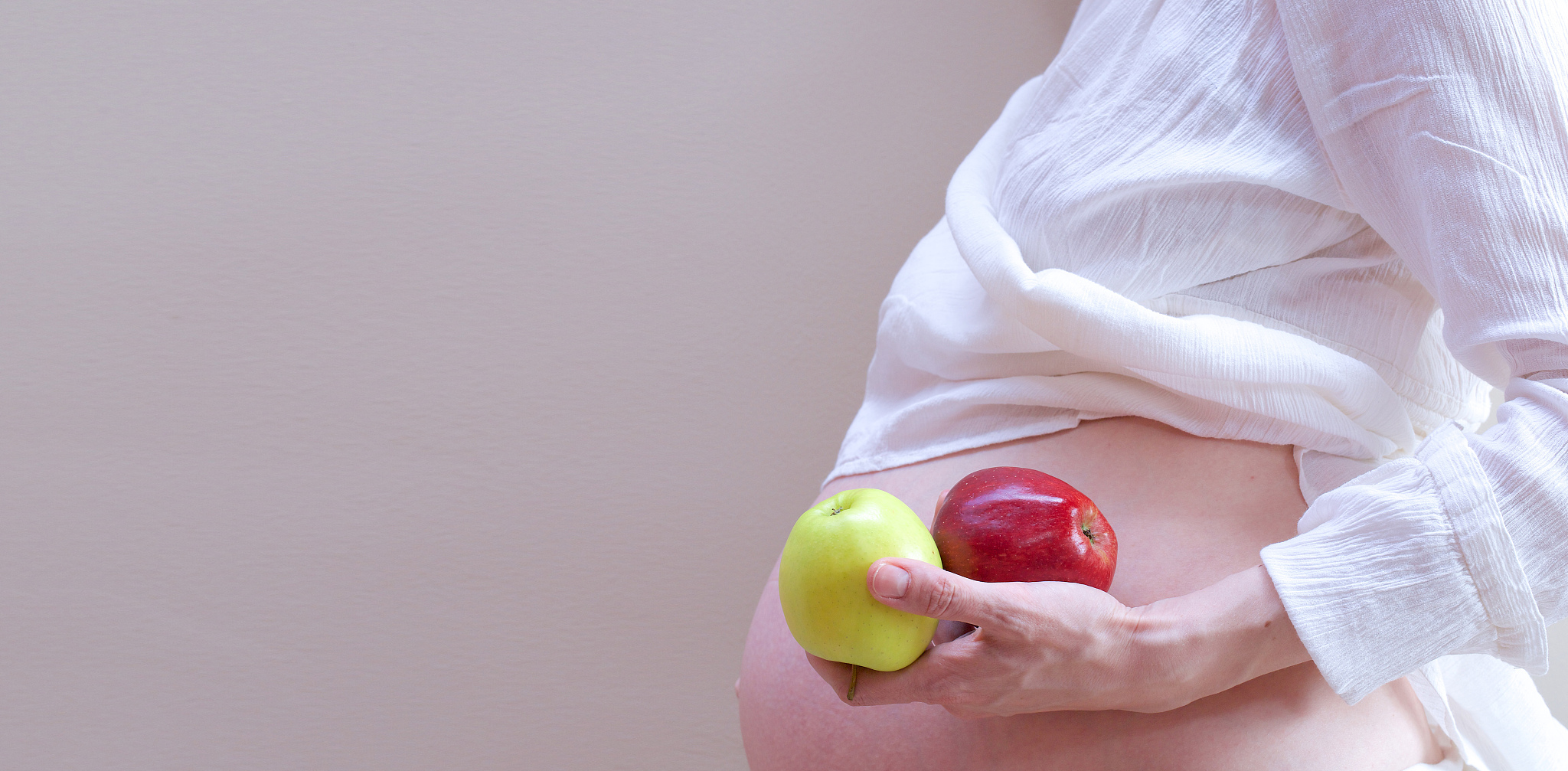 pregnant woman with two apples in her palm