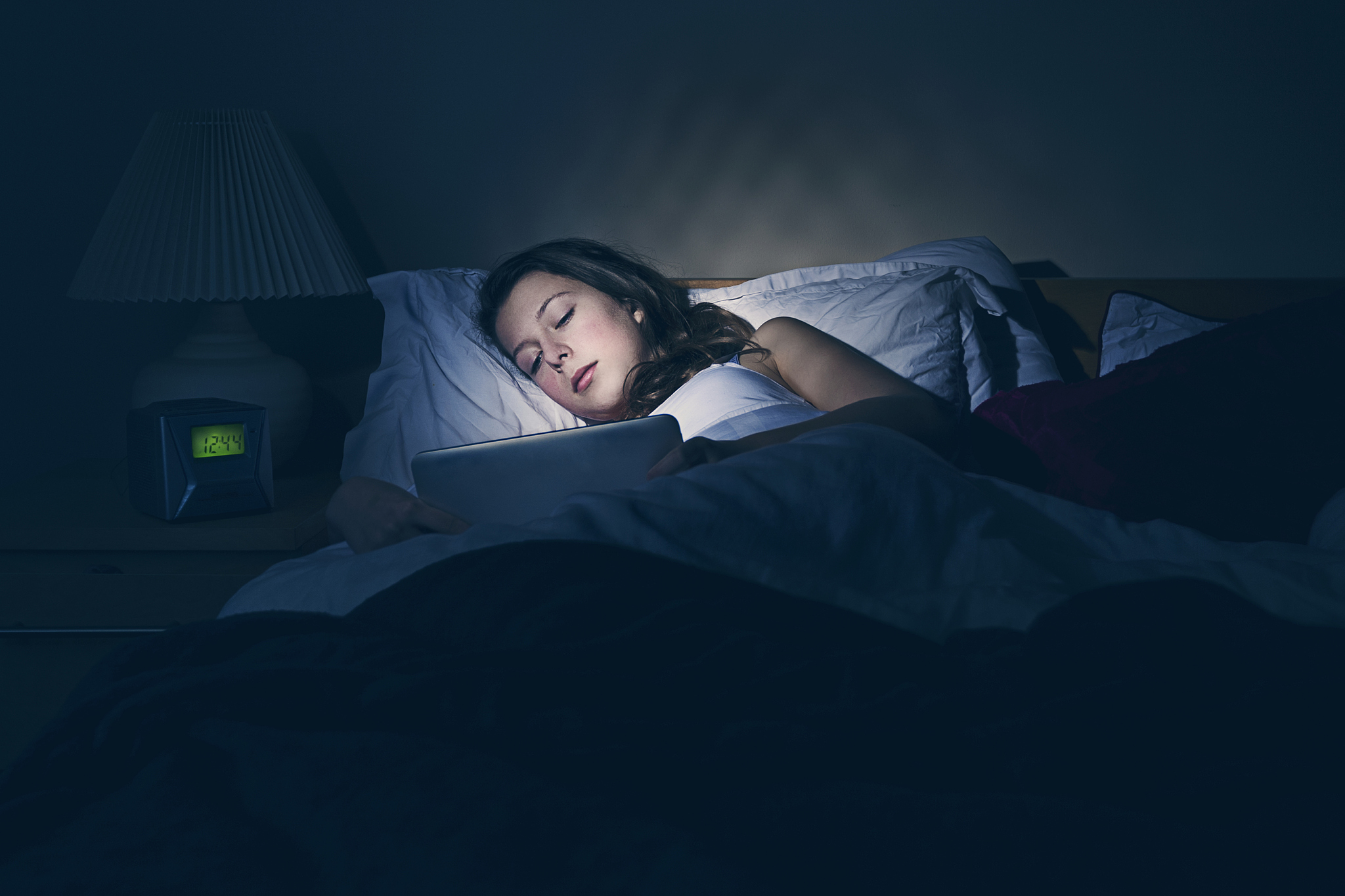 teenager using tablet in bed