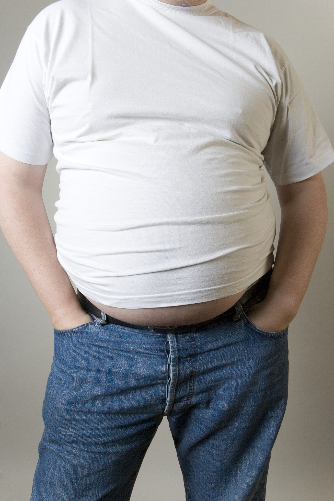 man wearing casual clothing with hands in pockets, mid section